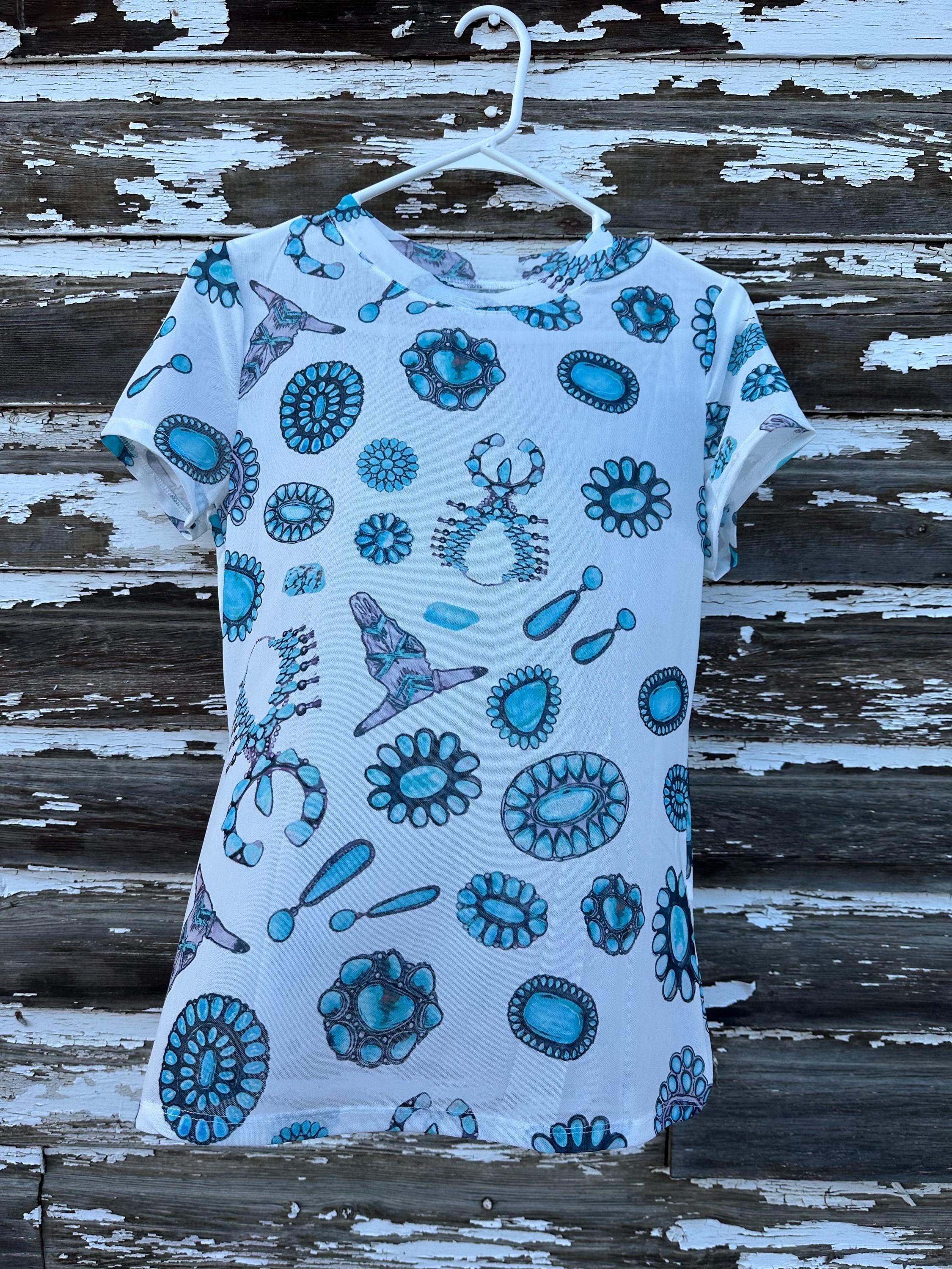 Add a touch of Western flair with this stylish Western Mesh Top! Featuring cow skulls, squash blossoms, and turquoise conchos, this sheer print tee is soft, comfy, and perfect for layering. Shop Razelsâships FREE with $35+ purchase