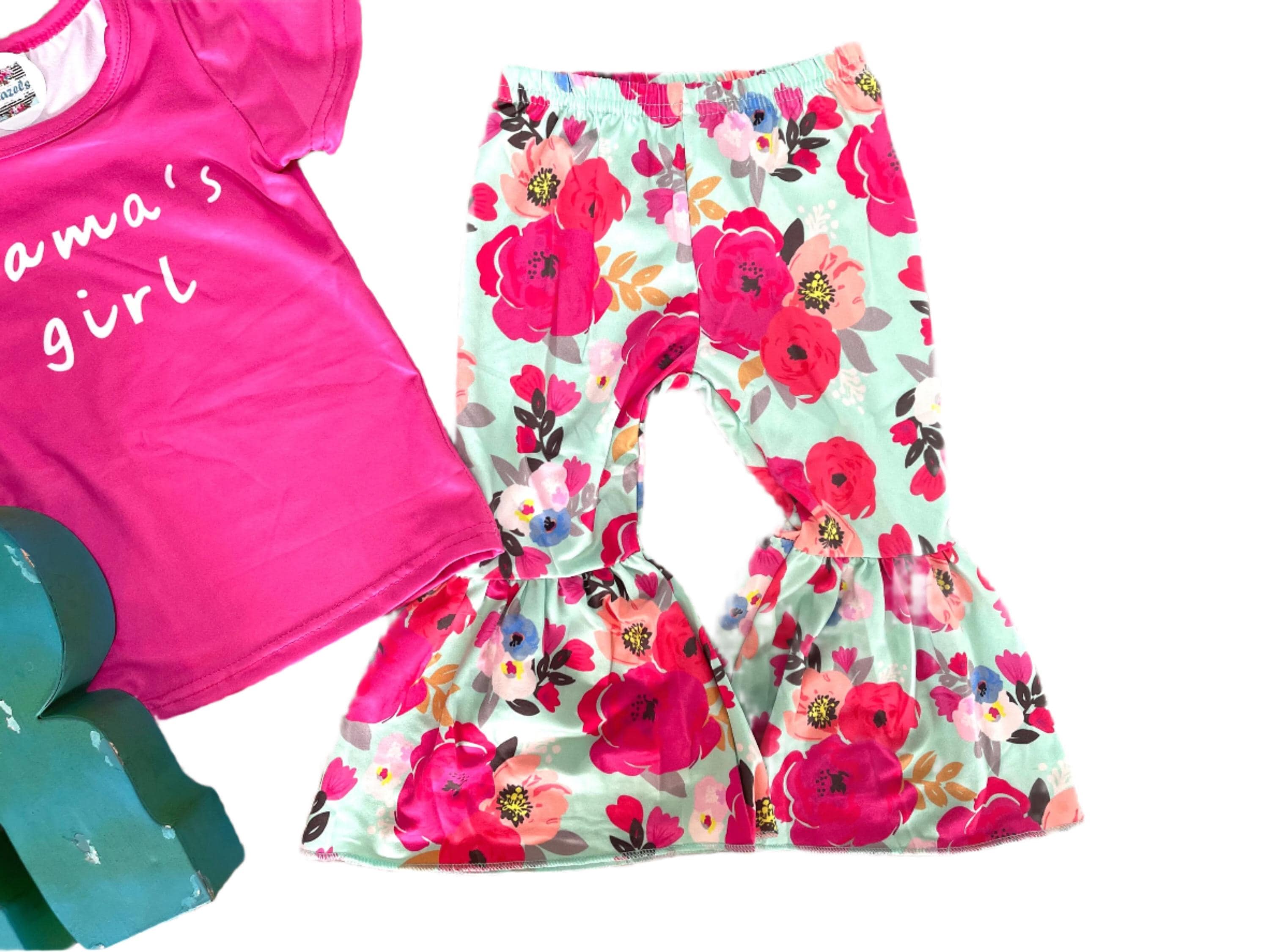 🌸 Just in Time for Mother’s Day – Now Only $10! 🌸
Limited Sizes Left: Only 3T & 4T Available!
Mama’s Girl Bell Bottom Outfit | Hot Pink T-shirt & Mint Floral Bell Bottoms
Celebrate spring and Mother’s Day in style with this adorably fierce outfit for your mini! Featuring a bold hot pink “Mama’s Girl” tee and twirl-worthy mint green floral bell bottoms, this set is made for the sassiest little sidekick.