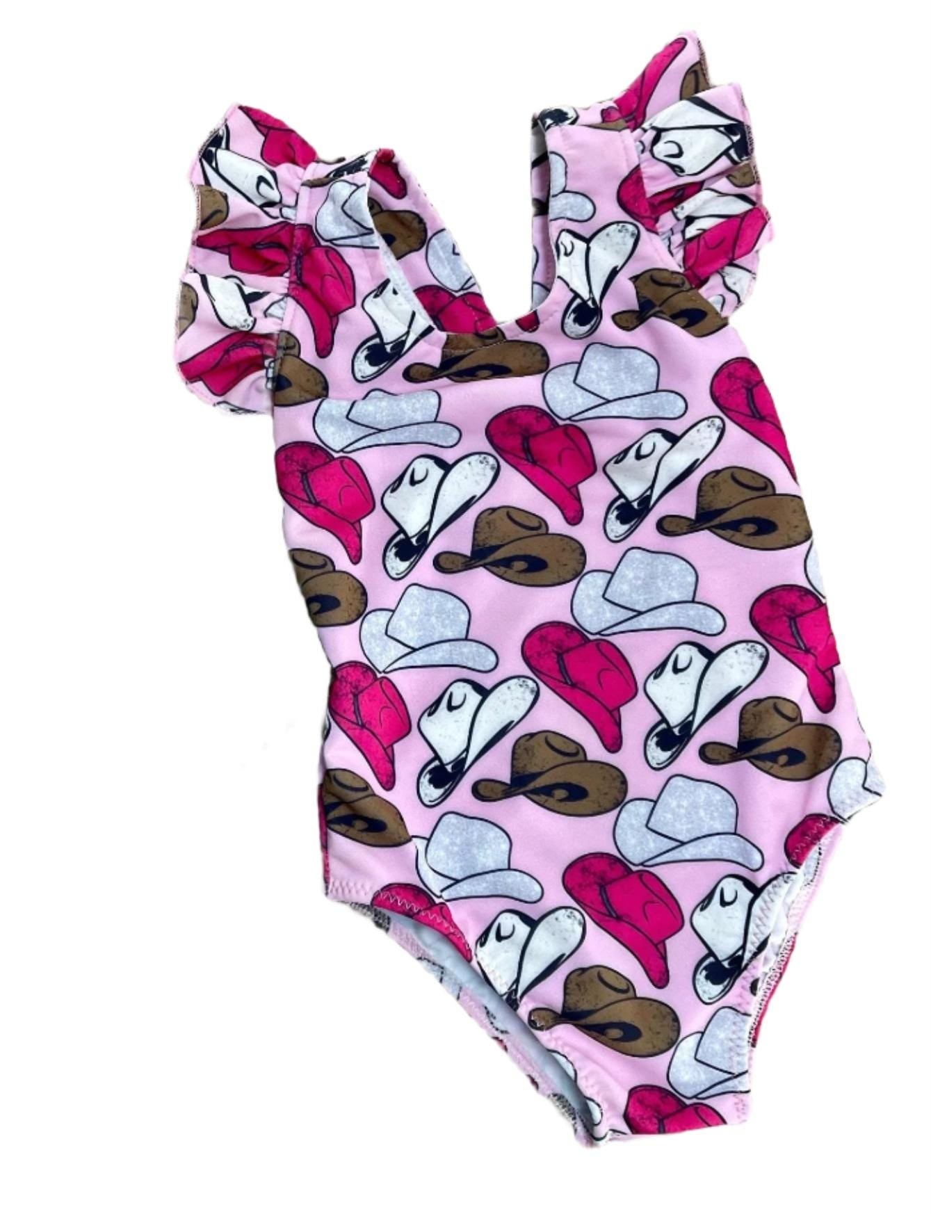Cowgirl Swimsuit | Pink Cowgirl Hat Swimsuit | Western Swimsuits Girls, Sweetheart of the Rodeo
The cutest Cowgirl Swimsuit is here! Featuring hot pink, silver, and brown cowgirl hats on a bubblegum pink background, this one-piece swimsuit is a must-have for little rodeo queens. The flutter neckline adds the perfect touch of sweetness, making it as adorable as it is stylish!
Ships FREE FROM MONTANA with any $35+ purchase!