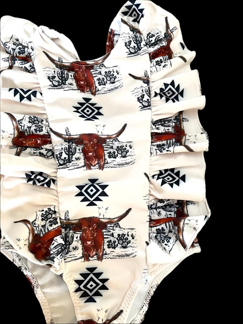 Western Swimsuits – Longhorn Steer Sibling Swimsuits. Get ready for summer with these Matching Swimsuits featuring a bold Longhorn Steer design! This black-and-white desert scene with a geometric touch is perfect for little cowboys and cowgirls who love Western style. 
 Cowboy Swim Trunks: Unlined for comfort, with a functional drawstring—also great as stylish day shorts!
Cowgirl Swimsuit: An adorable one-piece swimsuit with front ruffles fit for little rodeo queens!