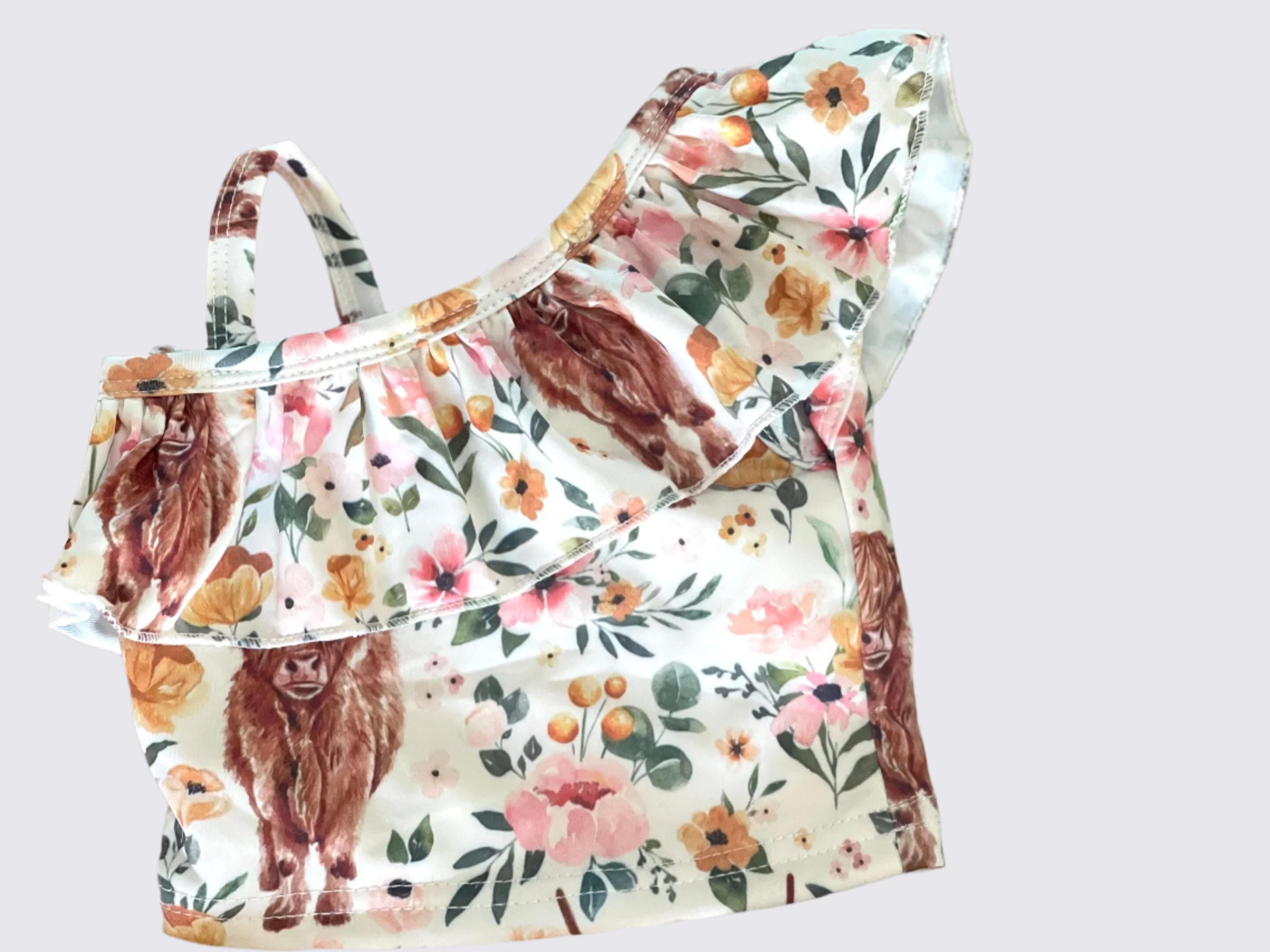 Highland Cow Swimsuit – The Sweetest Western Tankini! 🐂💖
Calling all Highland Cow lovers! This adorable Highland Cow Swimsuit features the funnest (yes, that's a word for this cuteness!) Scottish Highlander Cows and Flowers in a stylish tankini design. With a ruffled neckline and a skirted bottom, this Cowgirl Swimsuit for Kids is as sweet as it is fun! 🌸🐂
✔ Available Sizes: 0-3 months to 8/9!