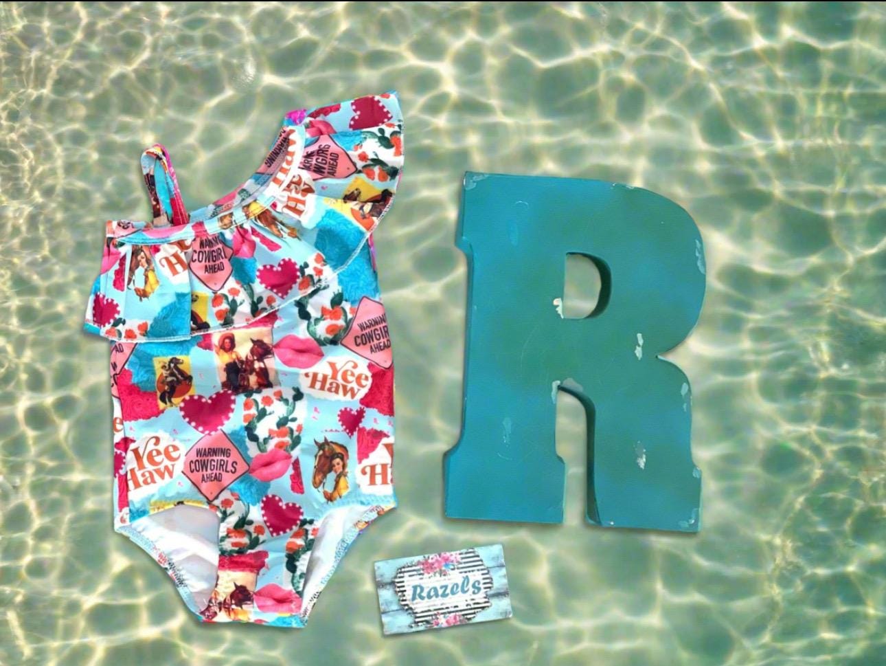 What a fun Cowgirl swimsuit!! 💗 Yeehaw!! Talk about Western Cutie! This fabulous 1-piece girls swimsuit features all the things we love about our Cowgirls - riding horses, hearts, cactus...a warning! So cute! I love this fabric so much it's also available in a girls blouse! 💞 • Available in sizes 0-3 months - 8/9! • Double layered front More Razels! Check out all our Western swimsuits and sibling swimwear. Ships FREE with $35+ purchase.