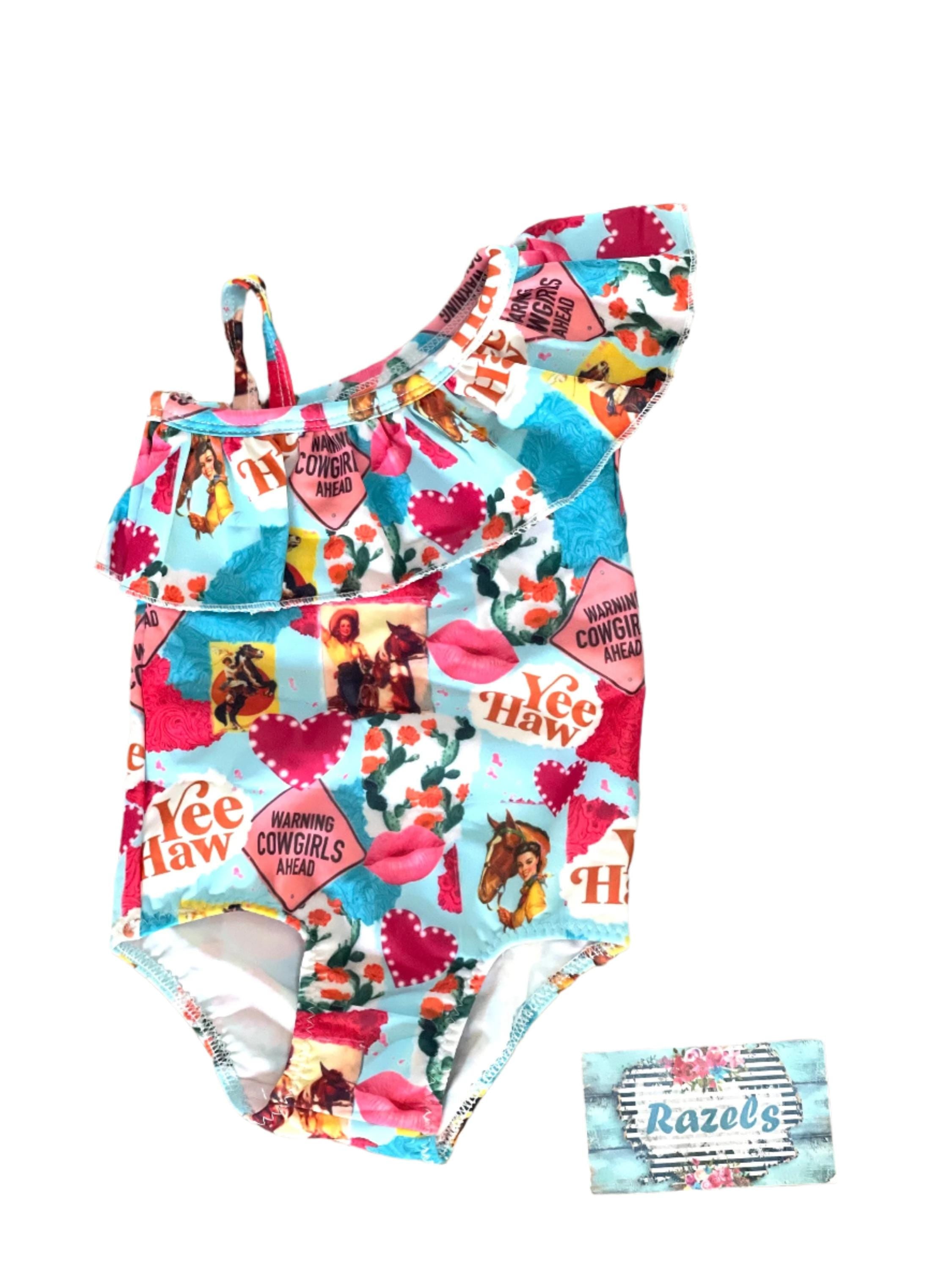 Yeehaw, Cowgirl Cutie! 🤠💗 This fun and fabulous Western Ruffled Swimsuit is perfect for little cowgirls who love adventure! Featuring a darling print of cowgirls riding horses, hearts, and cacti, this one-piece swimsuit is as cute as it gets. ✨ Why You’ll Love It: ✔️ Available in sizes 0-3 months to 8/9 – perfect for babies, toddlers, and big sisters! ✔️ Double-layered front for comfort and durability. ✔️ High-quality swimsuit material that’s made to last. 📦 FREE U.S. shipping on orders $35+