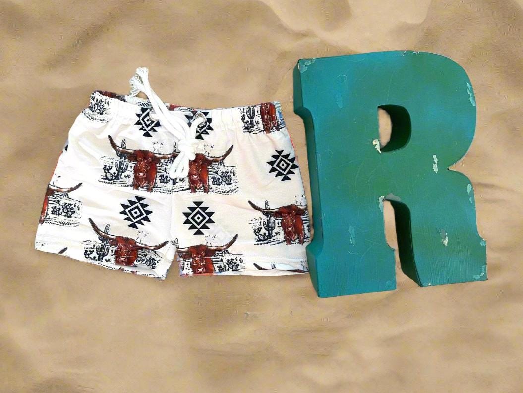 Western Swimsuits – Longhorn Steer Sibling Swimsuits. Get ready for summer with these Matching Swimsuits featuring a bold Longhorn Steer design! This black-and-white desert scene with a geometric touch is perfect for little cowboys and cowgirls who love Western style. 
 Cowboy Swim Trunks: Unlined for comfort, with a functional drawstring—also great as stylish day shorts!
Cowgirl Swimsuit: An adorable one-piece swimsuit with front ruffles fit for little rodeo queens!