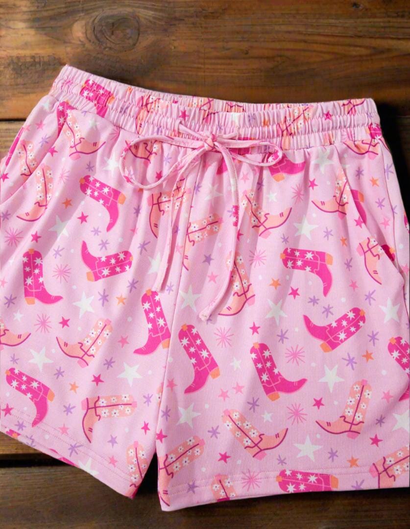 Pink Cowgirl Summer Pajamas | Western Lounge Set | Cowgirl Boot Pajamas 🌵 Cowgirl dreams meet summer comfort! This two-piece pajama set features an allover Western boots print in gorgeous shades of pink, orange, and white, accented by twinkling stars for the ultimate cowgirl vibe. Stylish, breathable, and oh-so-cozy! ✔ Two-Piece Set – Includes t-shirt-style top and matching shorts with pockets and a drawstring waist for the perfect fit. SHIPS FREE from MONTANA TODAY