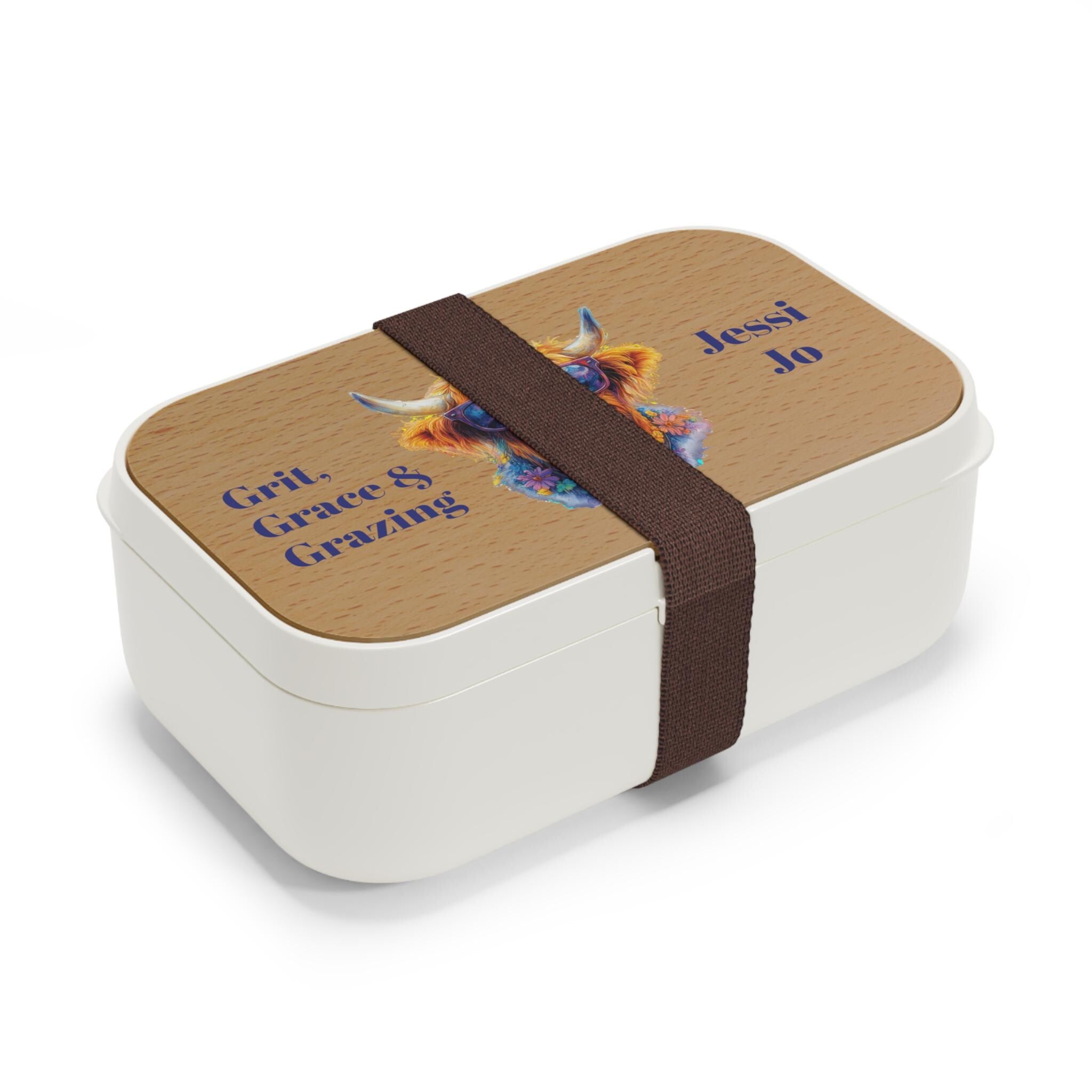 This Personalized Highland Cow Bento Lunch Box brings personality and practicality together in one adorable package. Featuring our flower-wearing Highland cow in sunglasses and the cheeky phrase “Grit, Grace & Grazing”, this custom lunch box is perfect for cow lovers of all ages.
 Customize with your name or saying
✓ Vibrant design with printed lid
✓ Two moveable compartment dividers for flexible storage
✓ Microwave-safe and easy to clean
✓ Durable 100% silicone + wooden lid