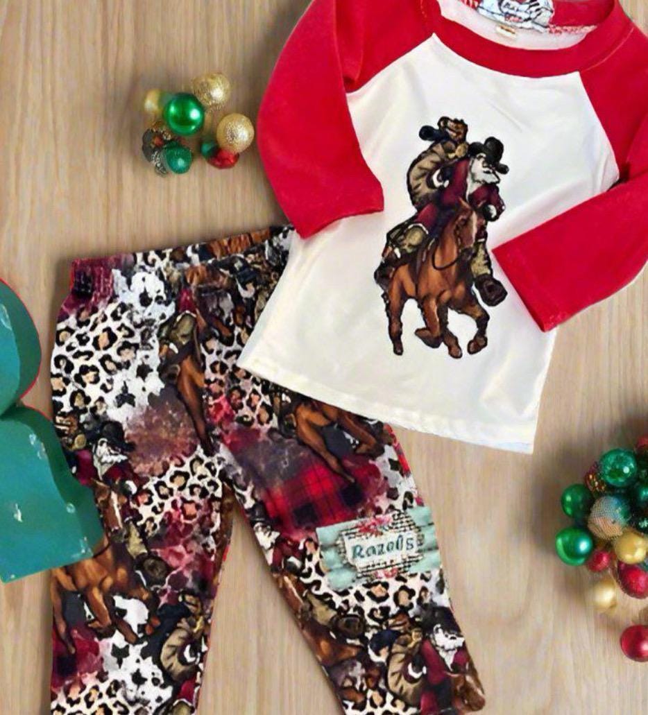 family cowboy Santa Christmas pajamas feature a raglan-style top with Santa riding his best horse, carrying a sack of packages. The top has red sleeves and neckline. The bottoms have an all-over cheetah print, buffalo plaid and Santa on his horse