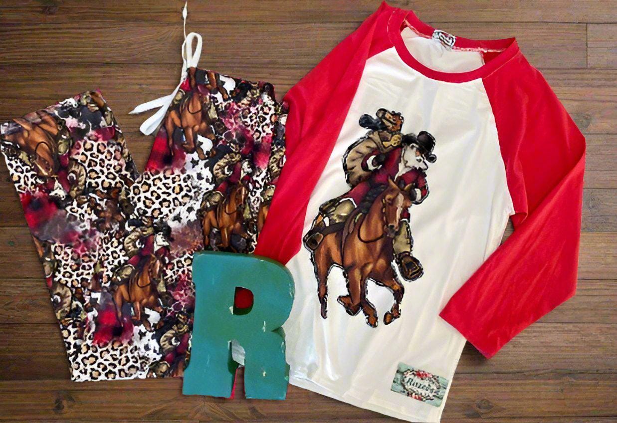 Cowboy Christmas Horse Family PJs with baseball t-shirt featuring Cowboy Santa delivering packages on his best horse, and Santa Jingle horse and cheetah print cover the comfy lounge pants. Cowprint Slippers are also available.