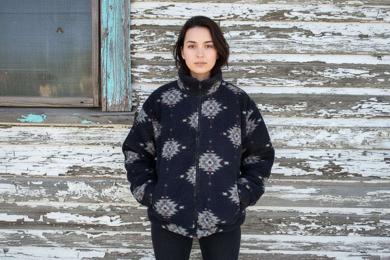 woman wearing Black jacket with white pattern standing in front of awooden surface