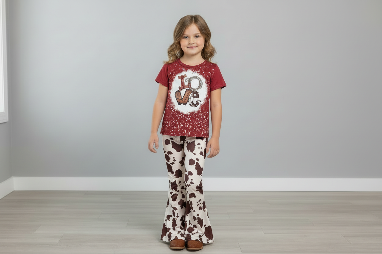 Red shirt with white splatter design and LOVE in western graphics and brown and white cowprint pants on a