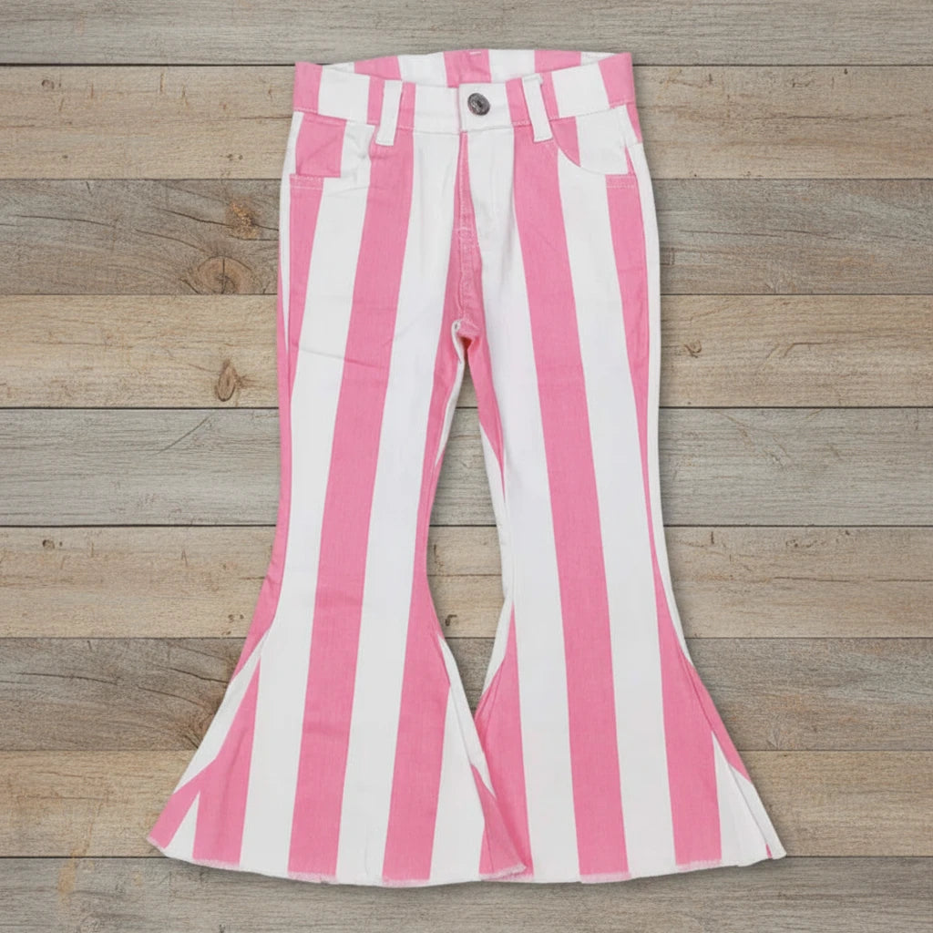 pink and white stripe flare jeans for girls against barnwood