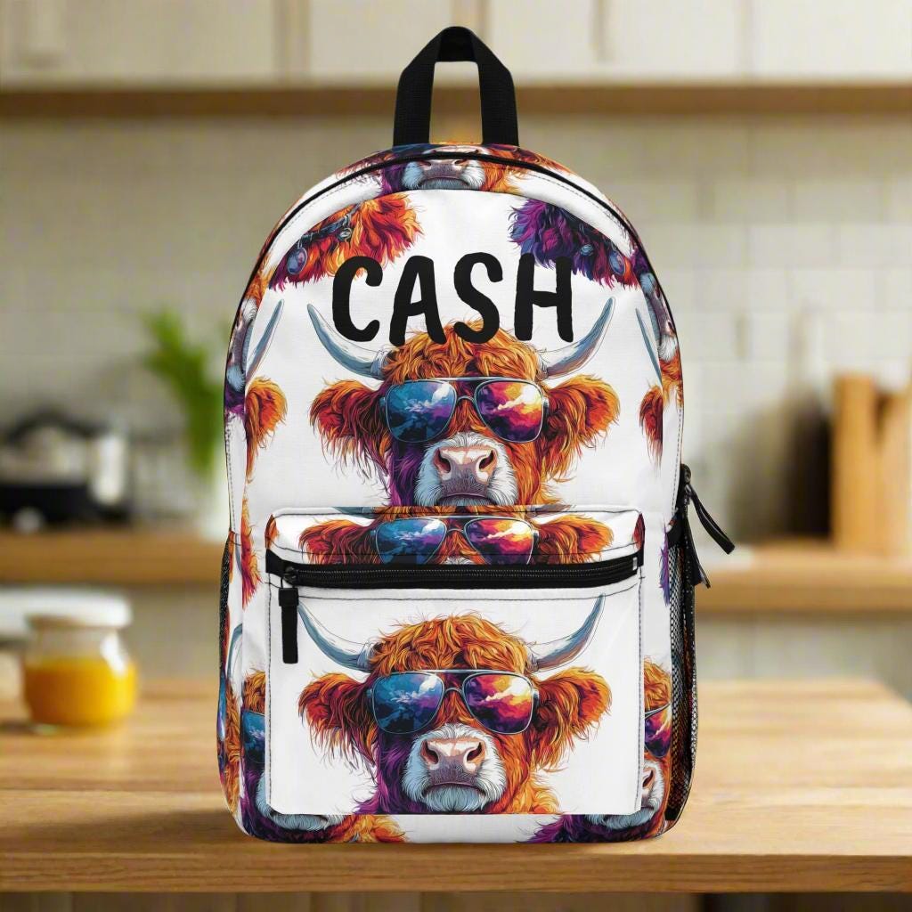 Backpack with a colorful design of a cow wearing sunglasses and the word 'CASH' on a kitchen counter.