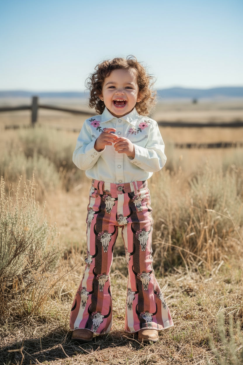 Flared pants with bull skull pattern on a textured white background