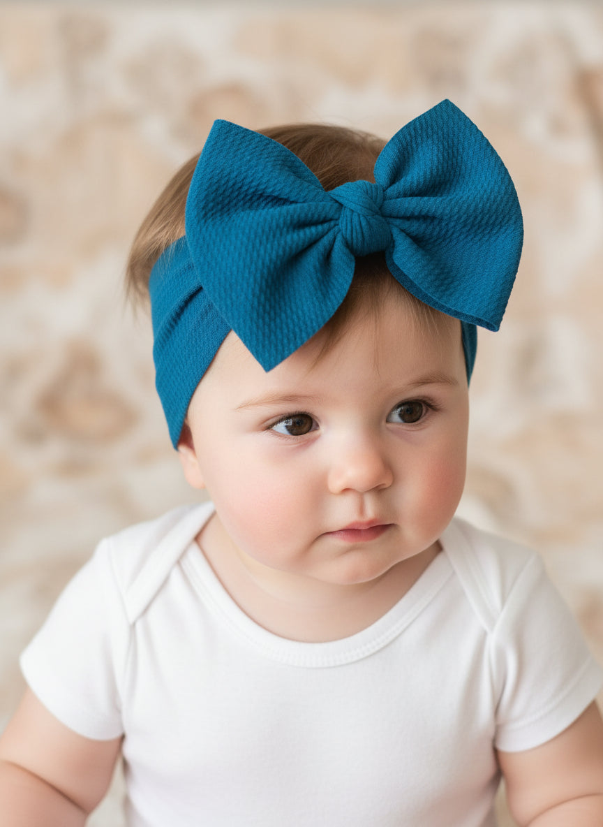 Teal Big Bow Headband These Big Bow Headbands for babies and toddlers are the perfect finishing touch to your little one's adorable outfit (also sold by Razels 😉). Soft, stretchy, and adjustable, they provide both comfort and style! And now, they’re available in even more colors!
✔ Hand-tied, not sewn, so you can adjust for the perfect fit