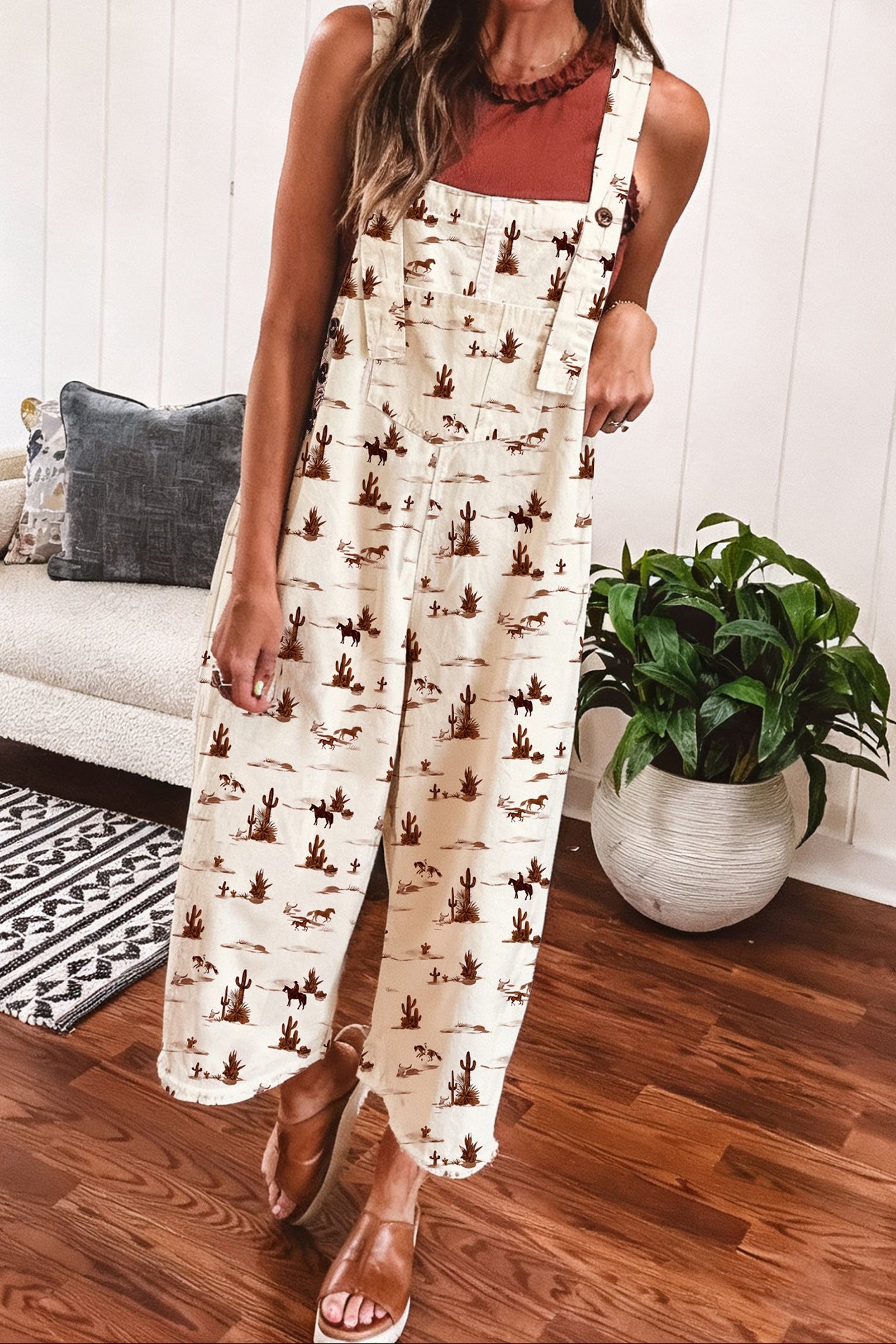 Woman wearing a cowboy print jumpsuit overalls in a living room setting