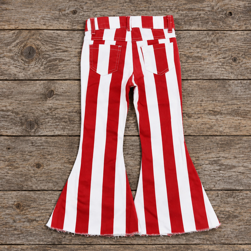 BACK OF GIRLS RED AND WHITE FLARE JEANS ON BARNWOOD