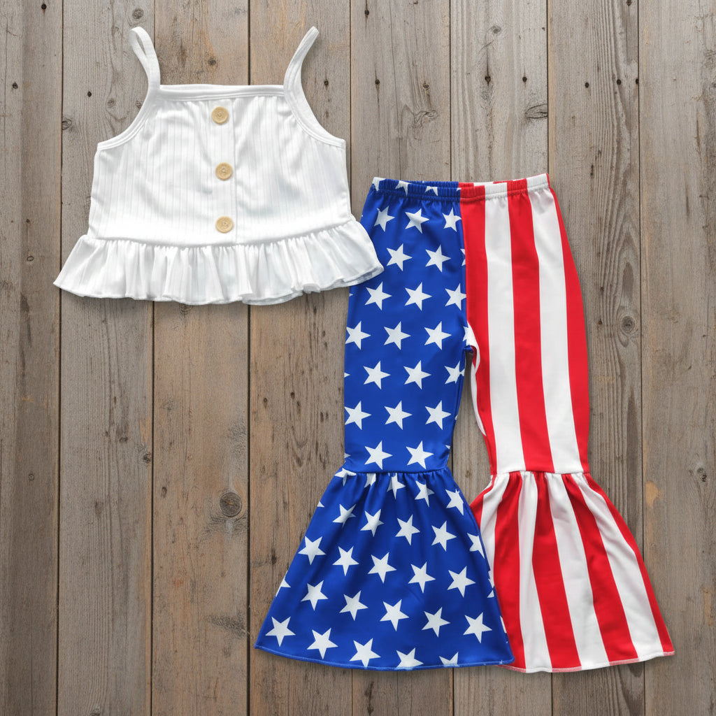 White top with ruffled details and American flag patterned pants on a textured gray background