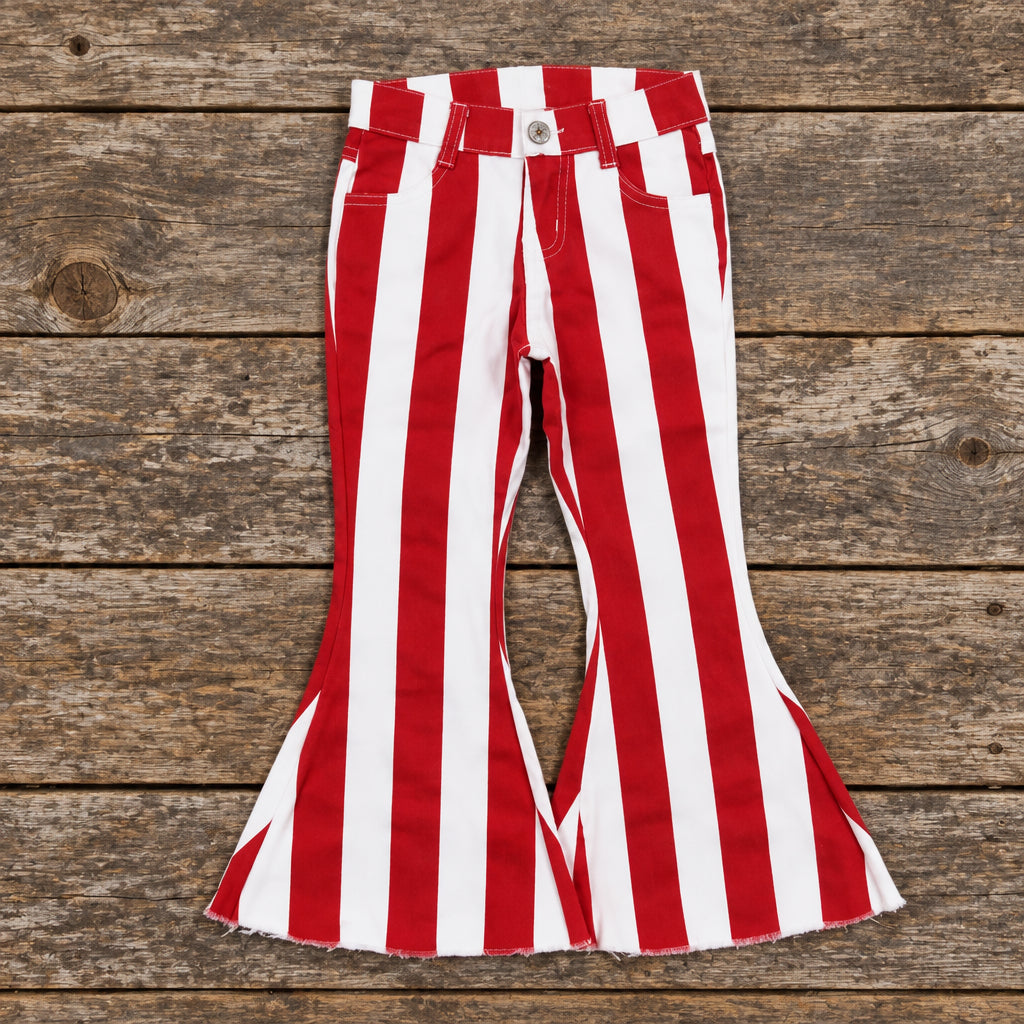 GIRLS RED AND WHITE FLARE JEANS ON BARNWOOD BACKGROUND