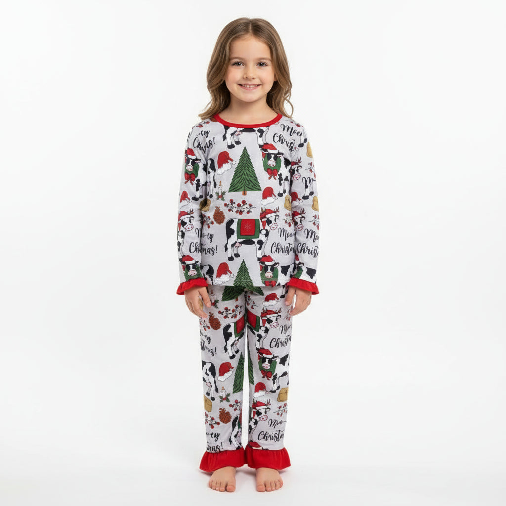 Children's Christmas-themed pajama set with cows, trees, and text on a white background