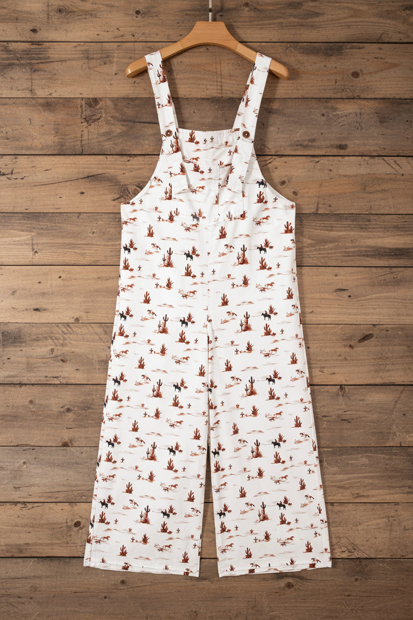 White overalls with brown desert cowboy print hanging on a barnwood wall
