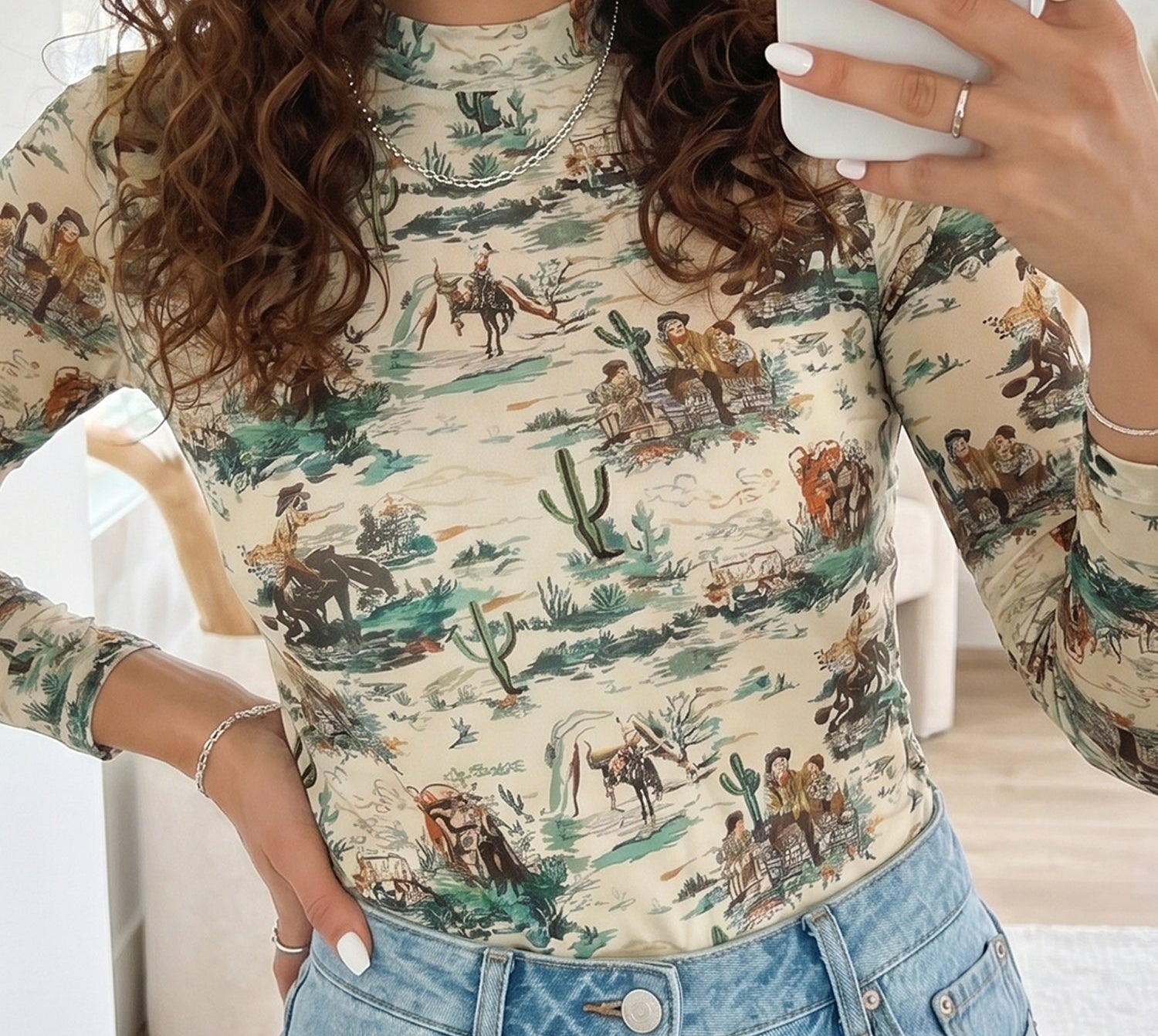 Woman wearing a long-sleeve Womens Vintage Western Mesh Top, Fall Cowboy Scenic Print Mock Neck Shirt and jeans, holding a white mug.