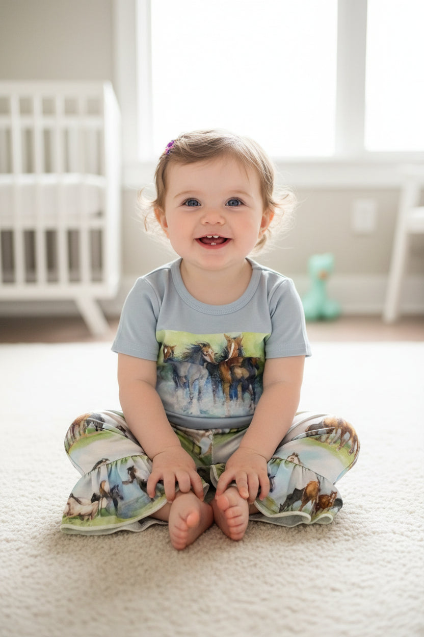 girl sitting on floor wearing razels baby girl vintage horse pant set