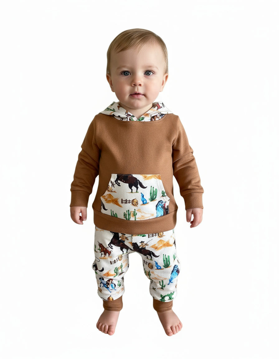 Little Cowboy Outfit – Exclusive to Razels!

Get your little cowboys ready for adventure with this Boys Western Outfit, the perfect blend of style and comfort! This playful set features a lightweight hoodie sweatshirt with a convenient kangaroo pocket and coordinating cowboy-print jogger pants. The retro cowboy design adds a fun and nostalgic vibe, making this outfit perfect for any little cowboy who loves to ride in style! 🤠 SHIPS FREE WITH $35 ORDER FROM MONTANA