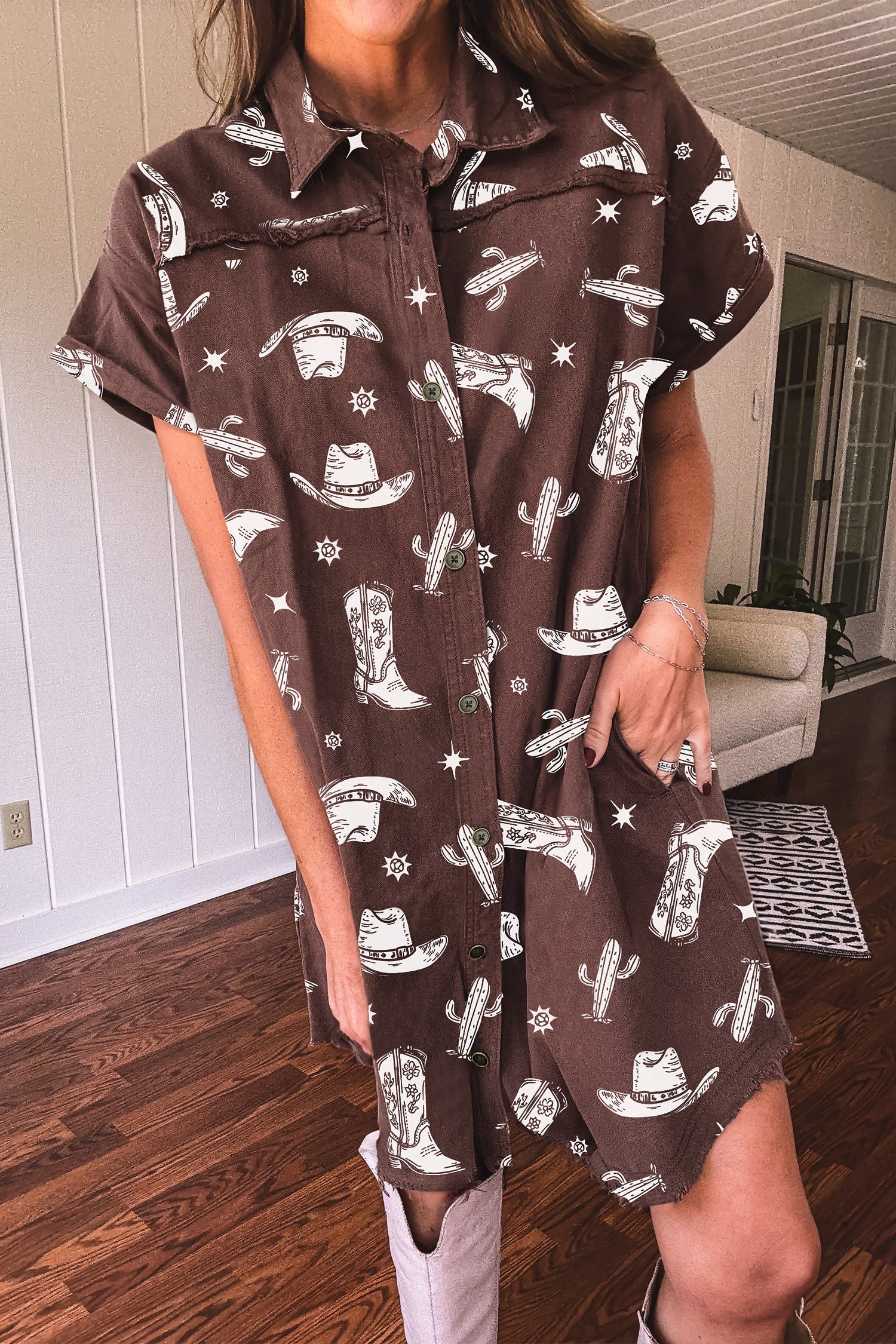 women wearing a brown dress with cowboy print in a room with wooden flooring.