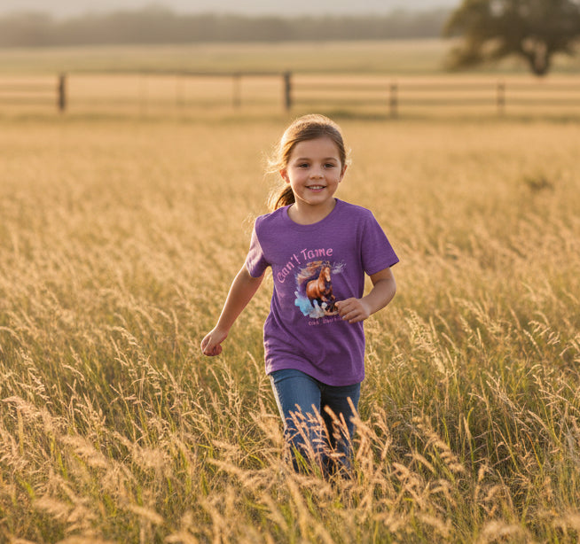 firl running through field wearing heather purple horse tshirt, can't tame the mustang