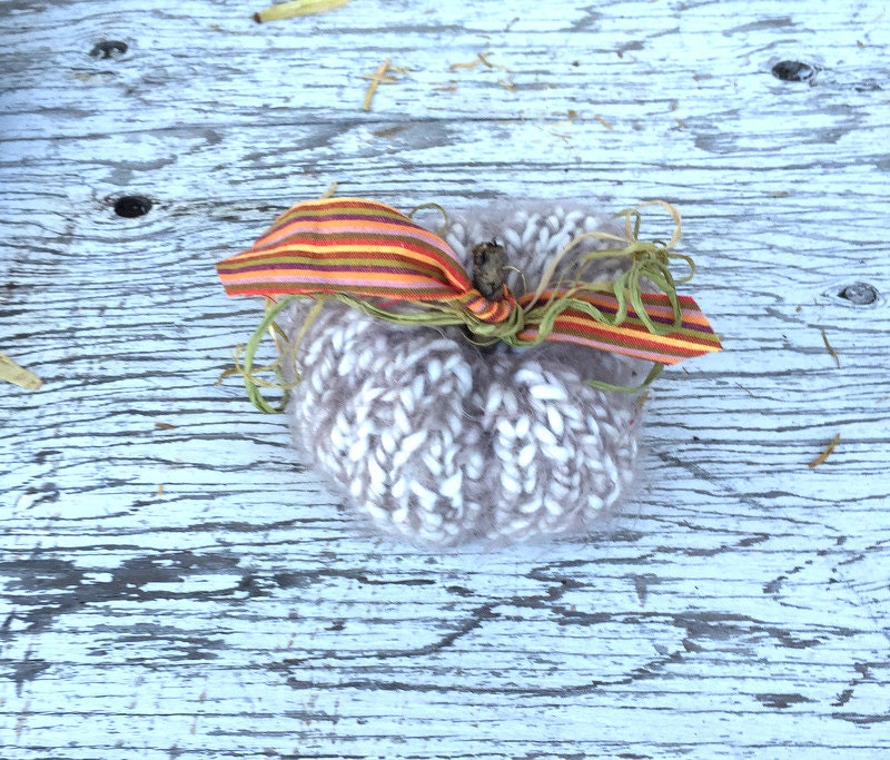 white Orange hand-knit pumpkin decoration. Pumpkins have sticks, raffia and fabric leaves, and vines.