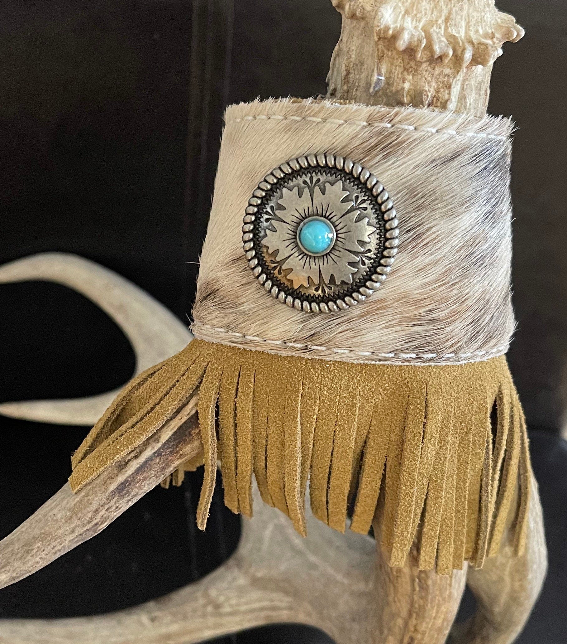 fringe 🔥 Brindle Leather Fringe Cuff with Tribal Silver Concho – One of a Kind! 🔥
Make a bold statement with this stunning Western cuff bracelet! Crafted from brindle hair-on-hide, this cowhide bracelet features a striking tribal silver concho and eye-catching leather fringe that hangs beautifully under the wrist with its unique diagonal cut.

✔ Premium brindle cowhide leather 
✔ Tribal silver concho –
✔ Diagonal-cut leather fringe – 
✔ Adjustable fit – fits up to a 7 ½” wrist
✔ 2” wide