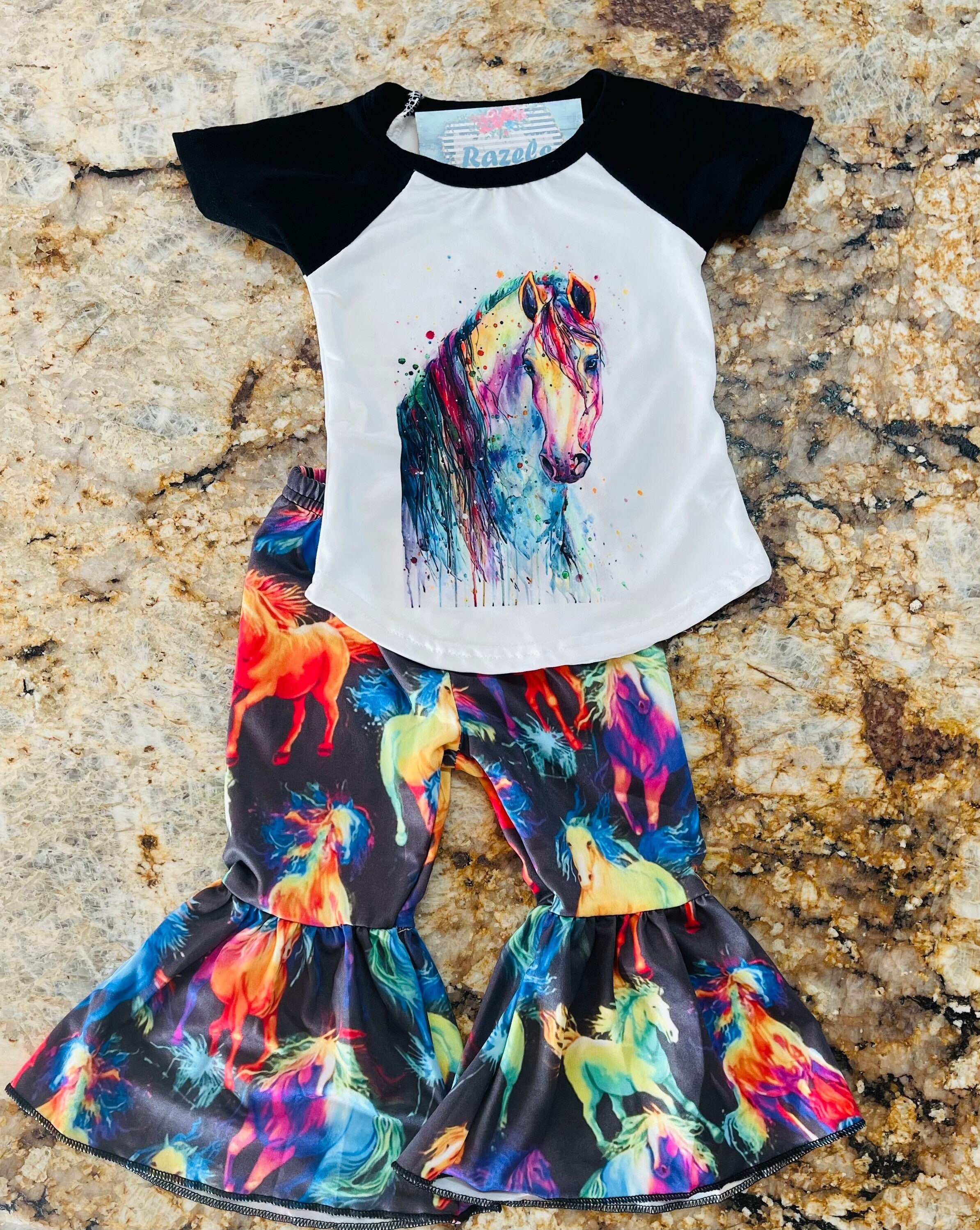 Neon Horse Bell Bottom Outfit -Perfect for Little Cowgirls
bell bottom outfit features a white baseball-style shirt with black sleeves, adorned with a stunning neon horse design, paired with bell-bottom pants showcasing a bold horse print