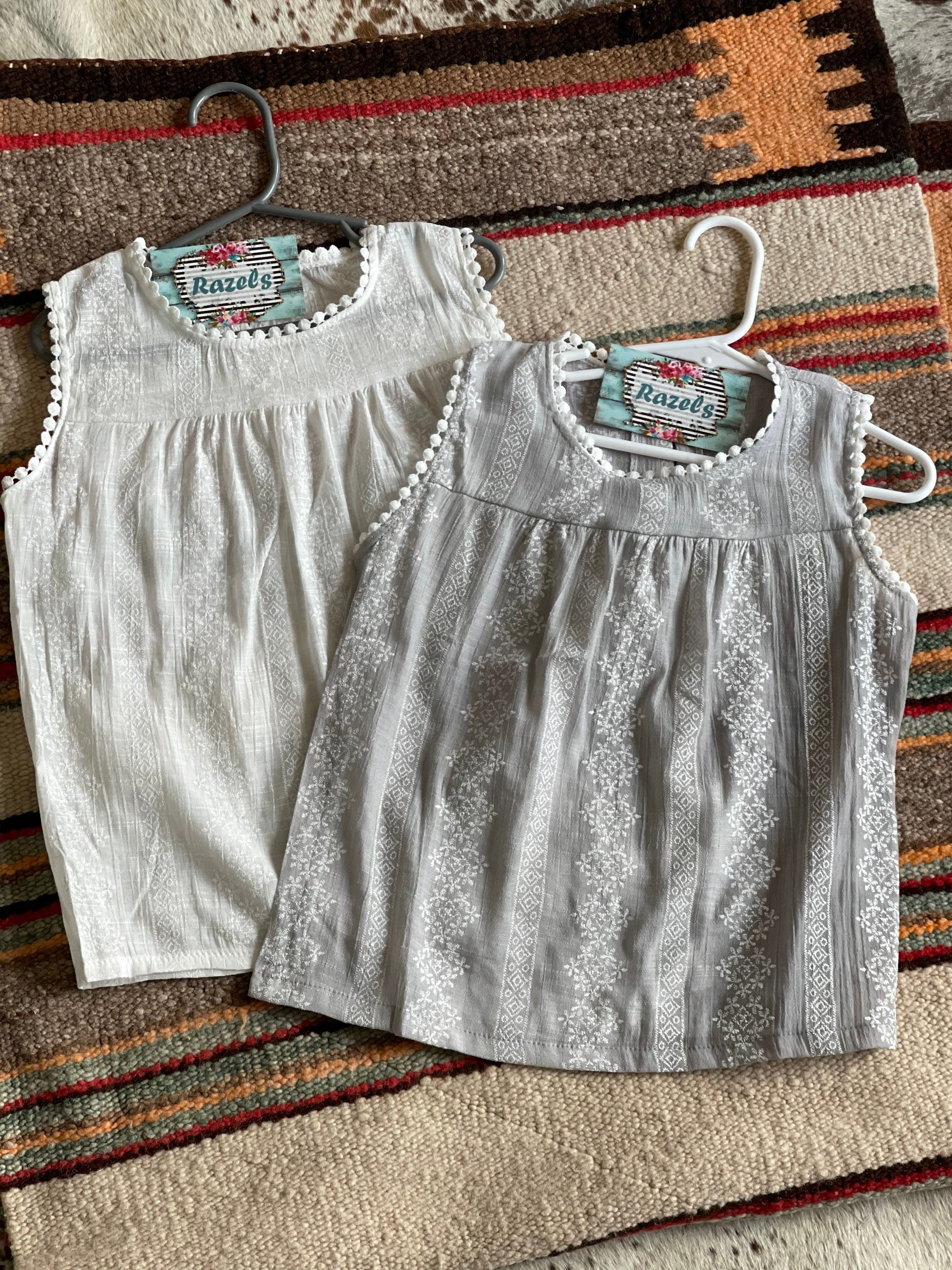 🌞 ONLY $10 – CLEARANCE SALE 🌞
We’re obsessed with these beautifully embroidered summer tanks—now just $10 while they last!

These girls’ tanks are lightweight, flowy, and packed with detail. Delicate embroidery, longer length for coverage, and a sweet boho feel make them perfect for every little fashionista.

✓ Wear it solo in the sunshine
✓ Layer it with a jean jacket or cardigan when the temps dip
✓ Flowy fit with room to grow

✓ Available in soft white or dusty gray