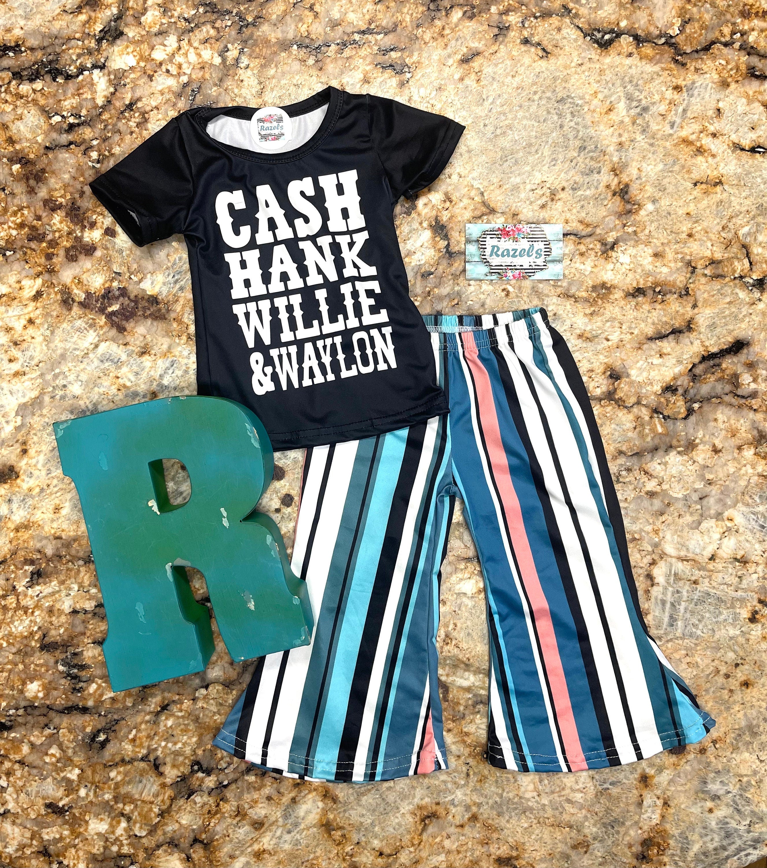 Girls Country Music bell bottom outfit. The outfit features black t-shirt with CASH, HANK, WILLIE, AND WAYLON scrolled across the front. Bell bottom pants feature stripes in pink, blue, black, white and turquoise.