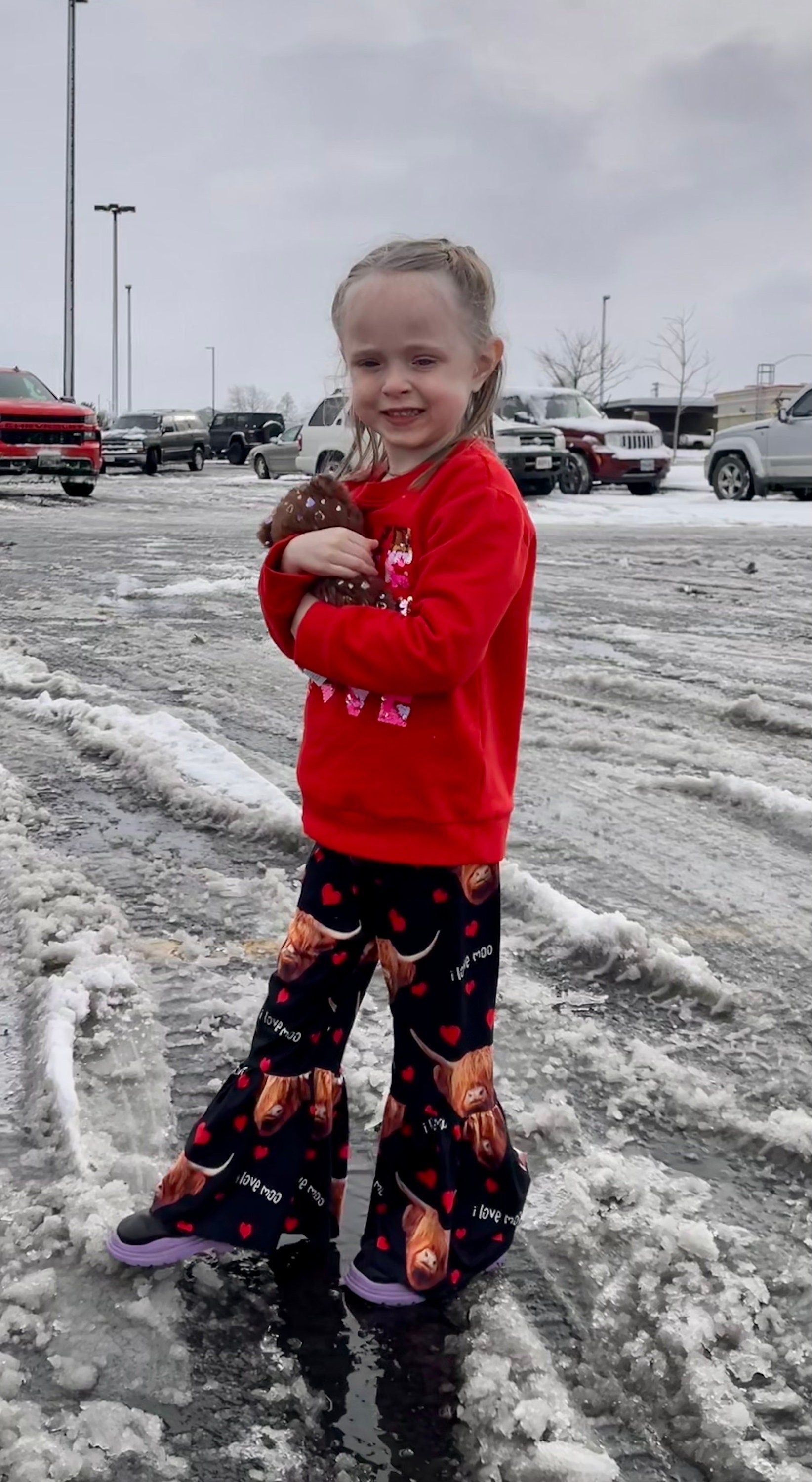 Jernie modeling her pants: Girls Black bell bottom pants that feature Scottish highlander cows, red hearts and the words I Love MOO