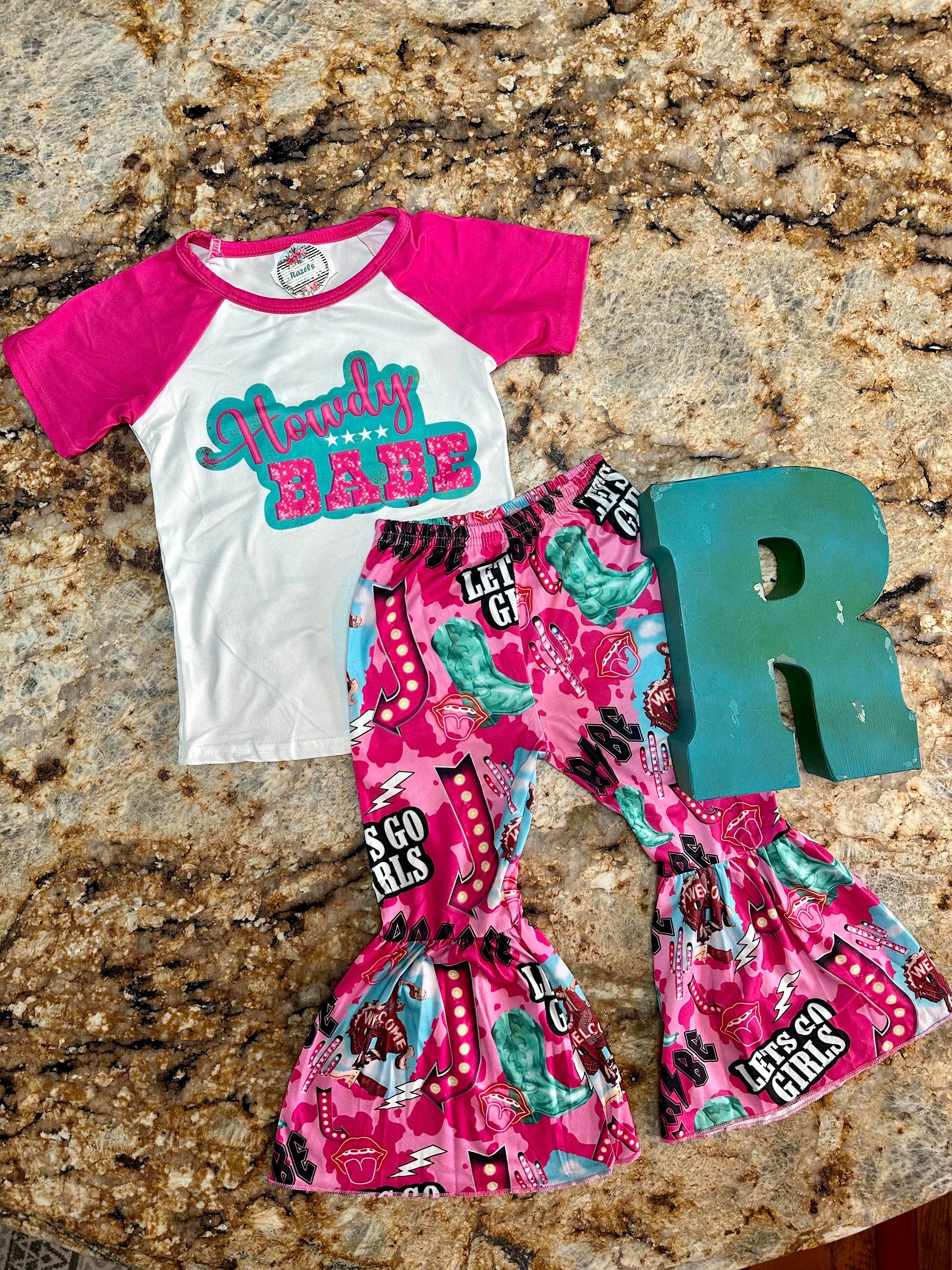 Bell bottom outfit - baseball style t-shirt with HOWDY BABE scrolled across the front and pink sleeves and pink bell bottoms with the funnest cowgirl motif - Let&#39;s go girls, bronc riders, neon signs, turquoise boots, lips and lightning bolts