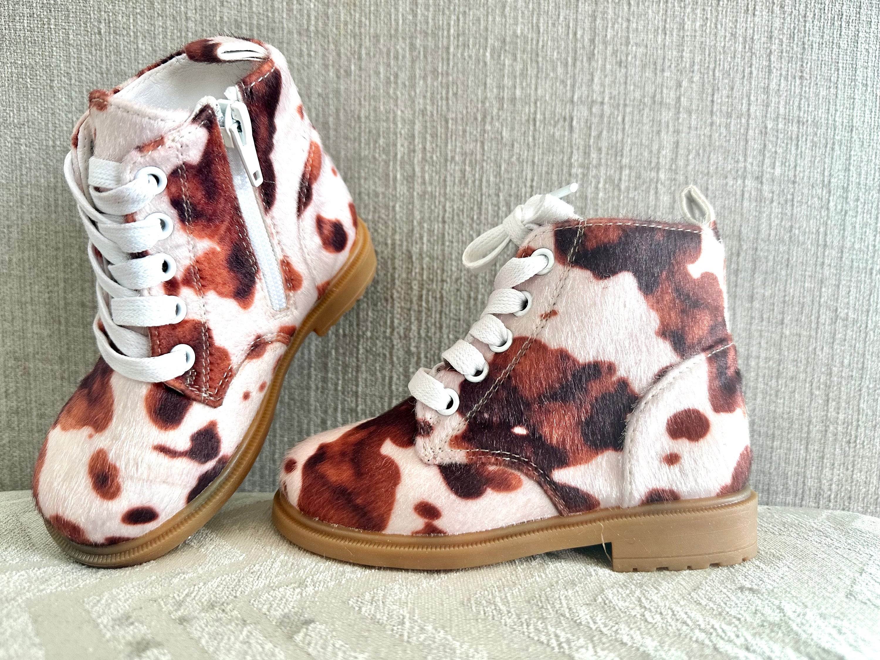 Cow Print Boots for Toddlers 🤎🤍 Yeehaw! These adorable cowprint boots are the ultimate statement piece for your little cowgirl or cowboy. Whether you&#39;re headed to the rodeo, school, or the playground, these toddler Western boots add a whole lot of charm to every step!  ✔️ Fun & stylish brown cow print ✔️ Side zippers for easy on & off ✔️ Durable rubber sole + comfy cotton/leather blend ✔️ Perfect for dressing up or down ✔️ Great for rodeos, family photos, fall fairs & more!