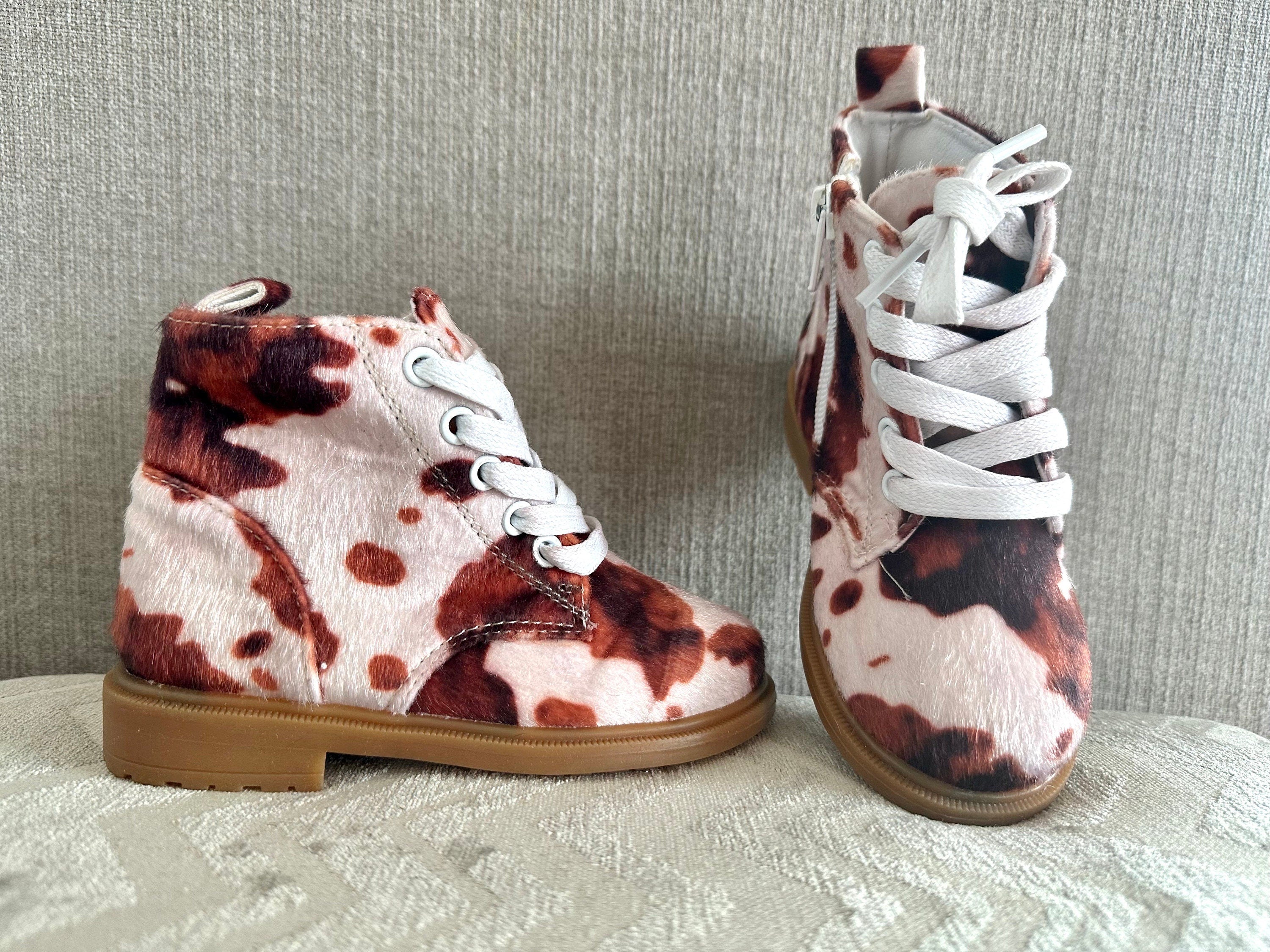Cow Print Boots for Toddlers 🤎🤍 Yeehaw! These adorable cowprint boots are the ultimate statement piece for your little cowgirl or cowboy. Whether you&#39;re headed to the rodeo, school, or the playground, these toddler Western boots add a whole lot of charm to every step!  ✔️ Fun & stylish brown cow print ✔️ Side zippers for easy on & off ✔️ Durable rubber sole + comfy cotton/leather blend ✔️ Perfect for dressing up or down ✔️ Great for rodeos, family photos, fall fairs & more!