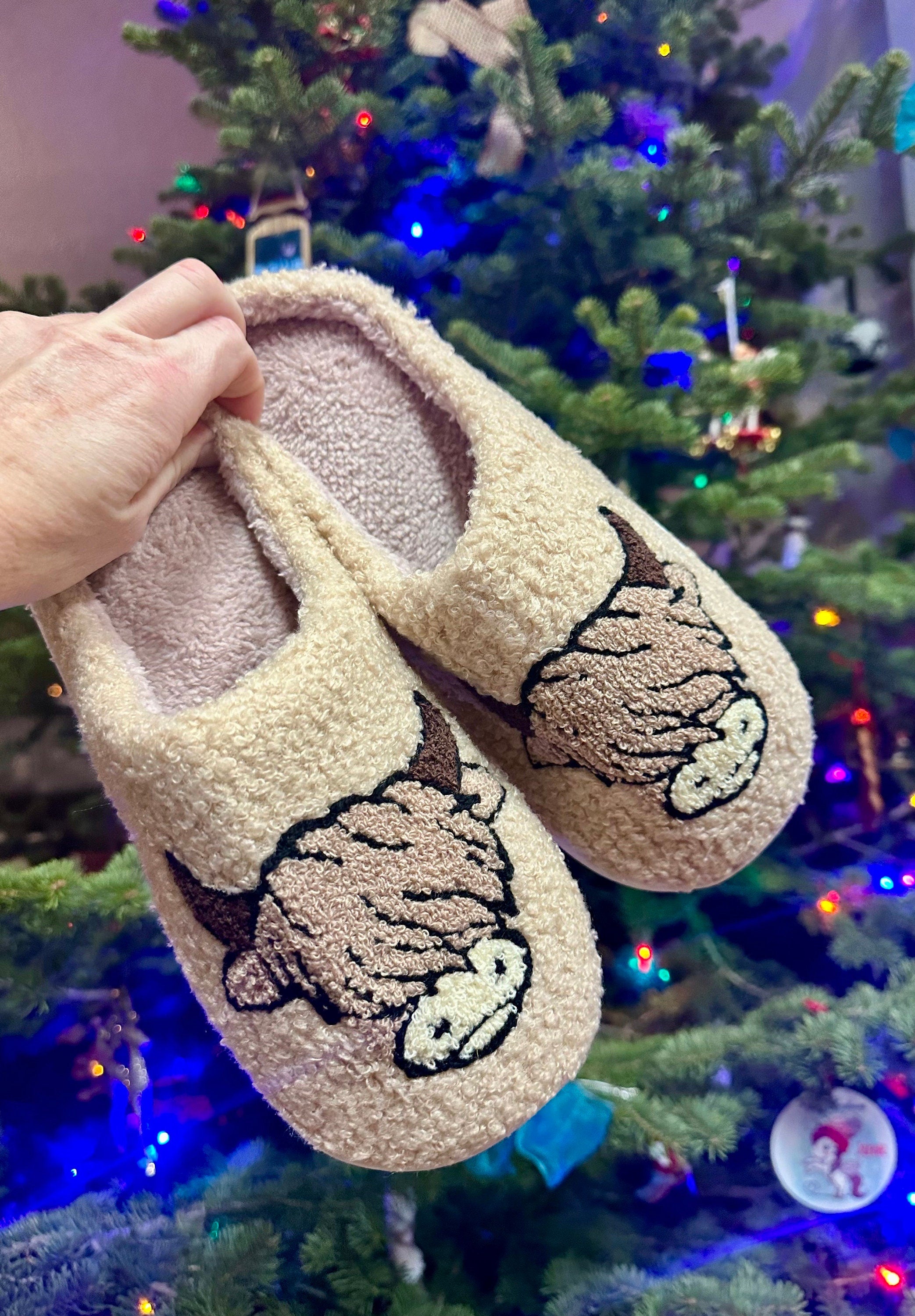 Comfy Scottish Highlander Slippers available in Beige, White and Black. These Western Cow Slippers feature the cutest highlander cow and are so comfy you&#39;ll never take them off! With a rubber sole, you can trek inside and out!