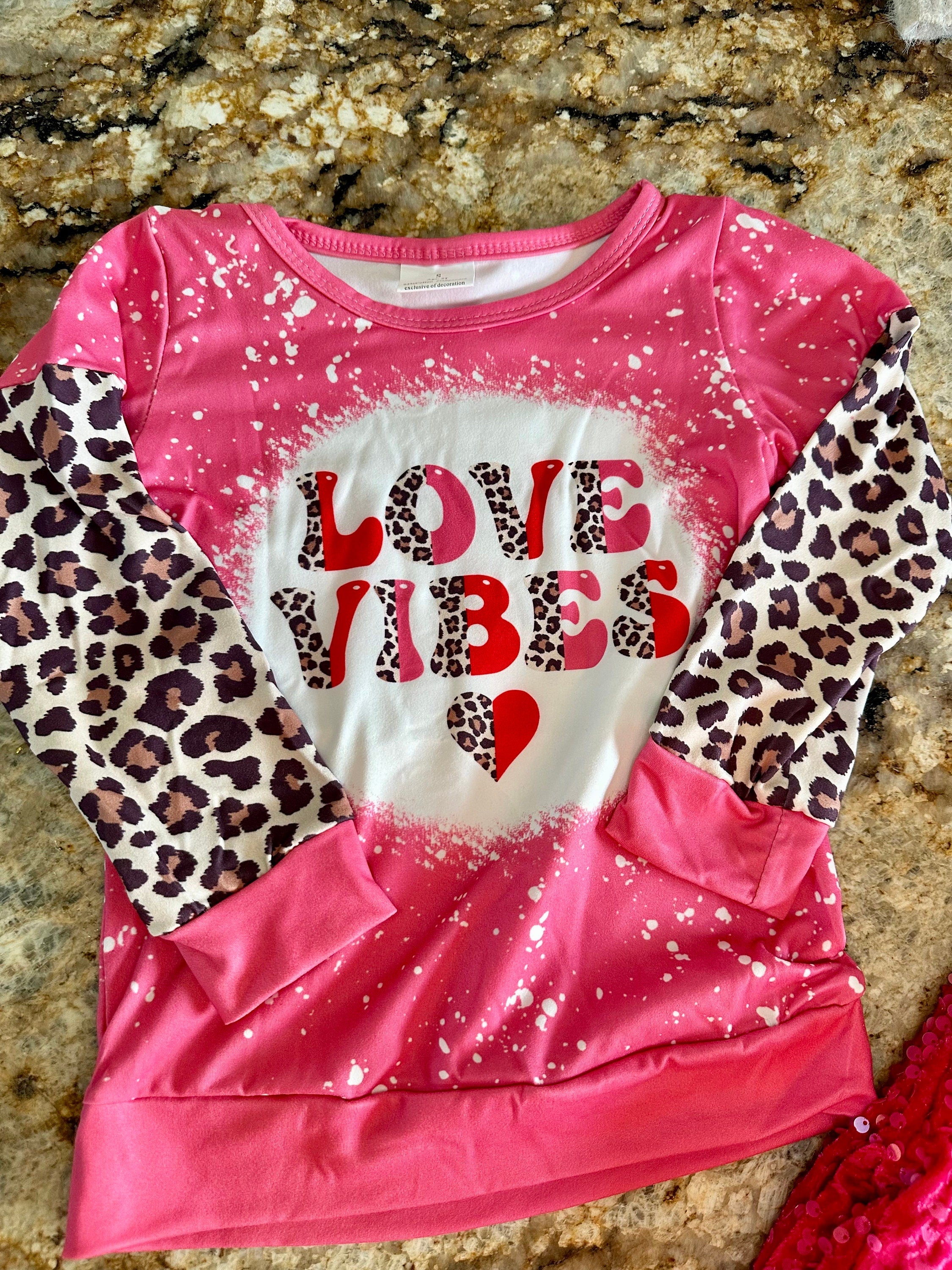 Girls Love Vibes Shirt with animal print sleeves.