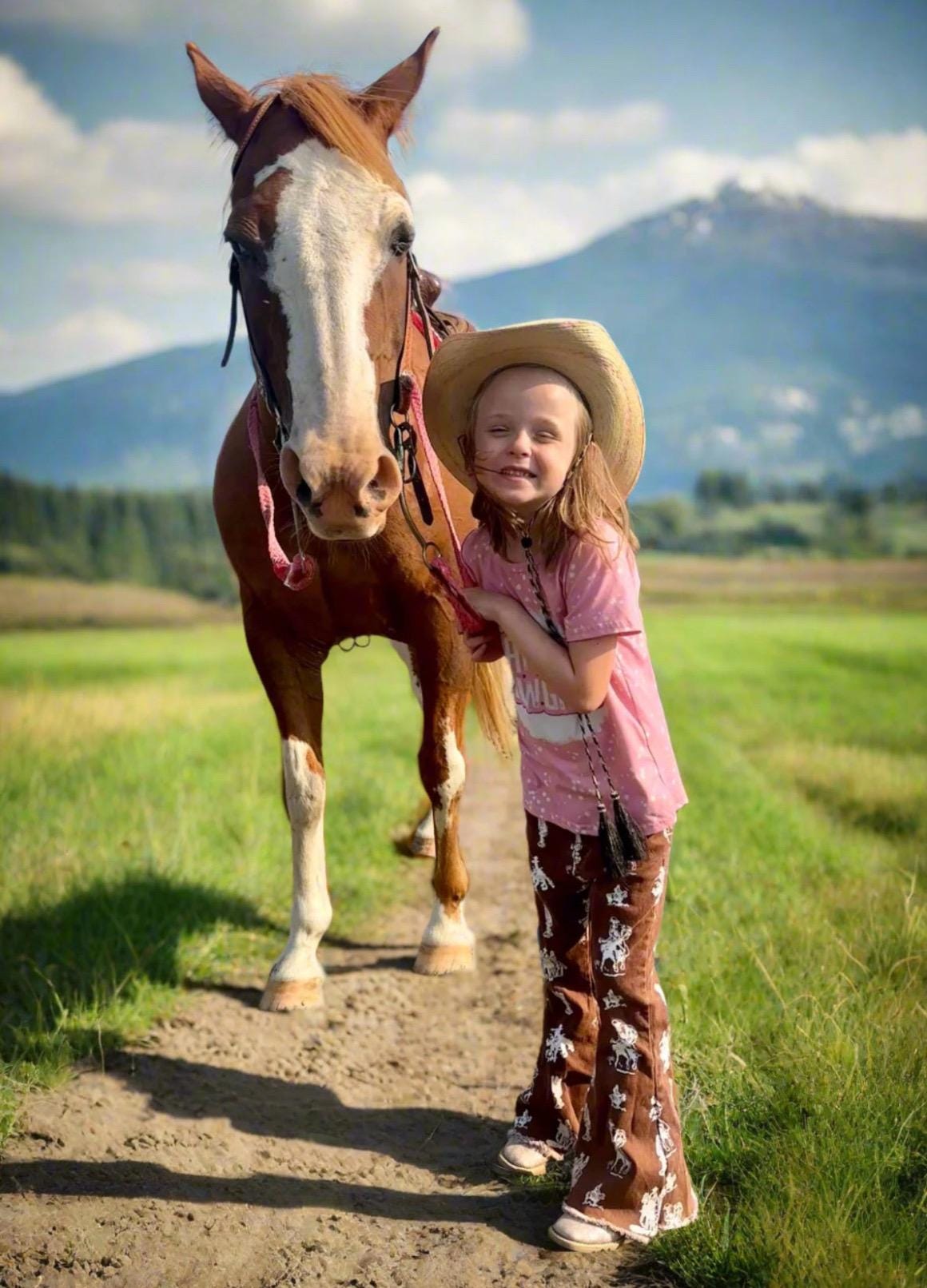 Brown Vintage Cowboy Bell Bottom Jeans featuring a vintage cowboy print, adjustable waistband, functioning pockets, and frayed bells. Styled with a matching Mama&#39;s Cowgirl T-shirt. Ideal for dressing up or down, perfect for little cowgirls.&quot;