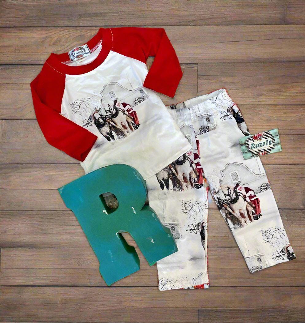 Family White Christmas Pajamas feature Santa Claus at the reins of a horse-drawn sleigh, pulling away from a vintage barn on a snowy winter day. The top has coordinating red raglan sleeves, and the bottoms feature a festive Santa print all over