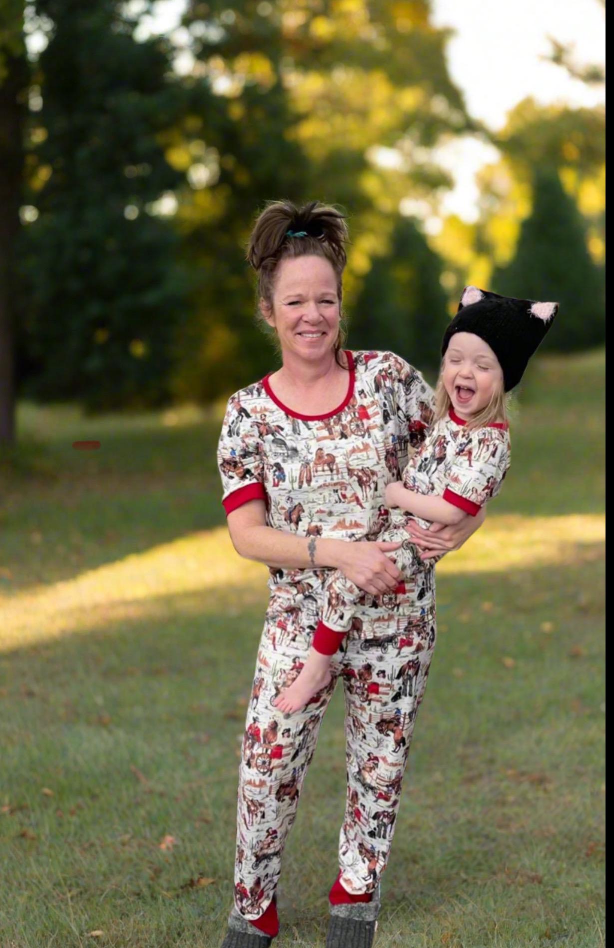 A cowgirl pajama set featuring a cheerful design of a cowgirl who can rope, ride broncs, and sing—complete with her trusty horse and dog by her side! Cute and soft and also available in matching mom size!