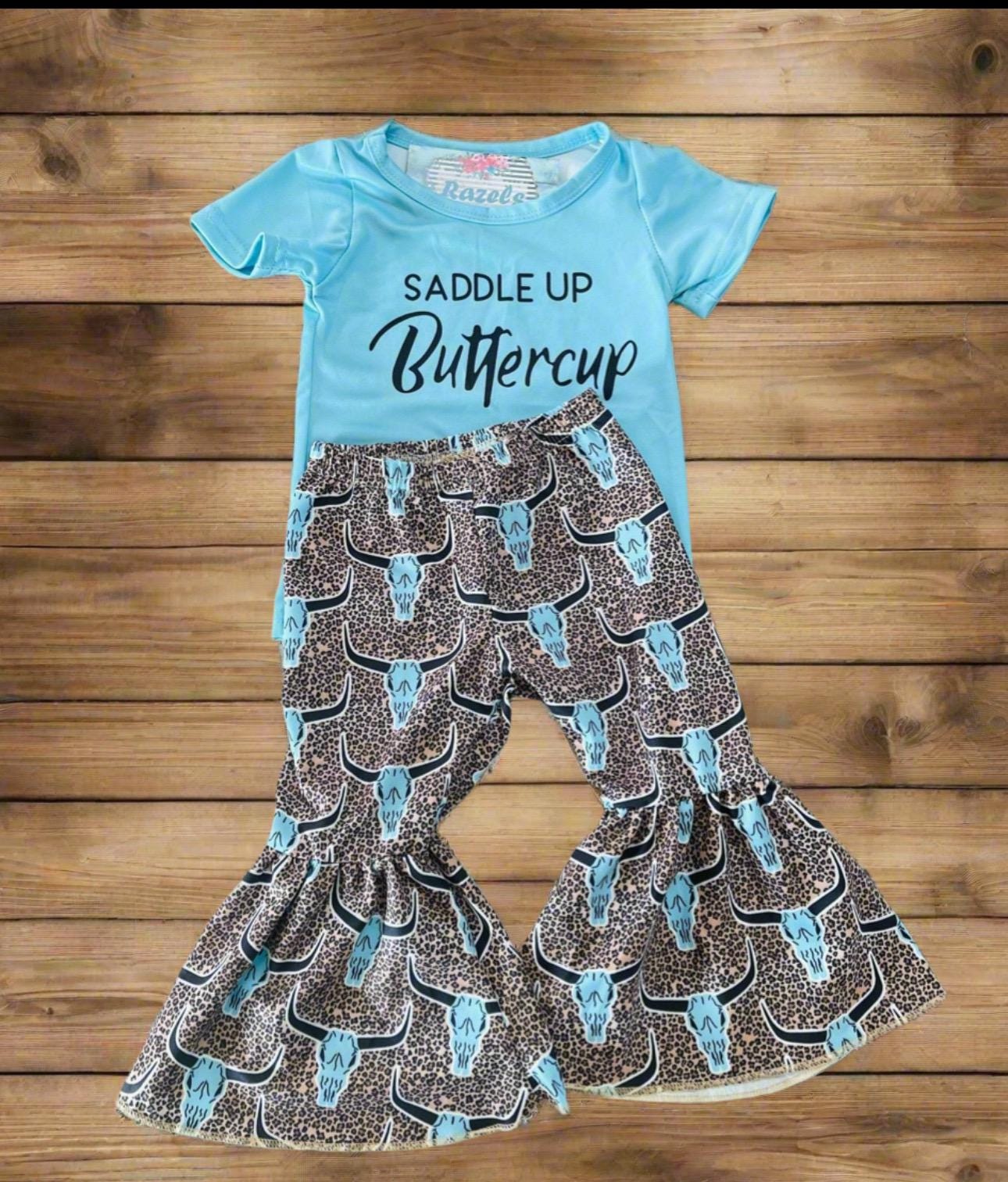 Saddle Up Buttercup! Girls Bell Bottom Outfit, Cowgirl Outfit, Turquoise T-Shirt & Cow Skull Cheetah Print Flares. Featuring a vibrant turquoise t-shirt and flared cow skull cheetah print bell bottoms - a showstopper for any Western-loving girl.