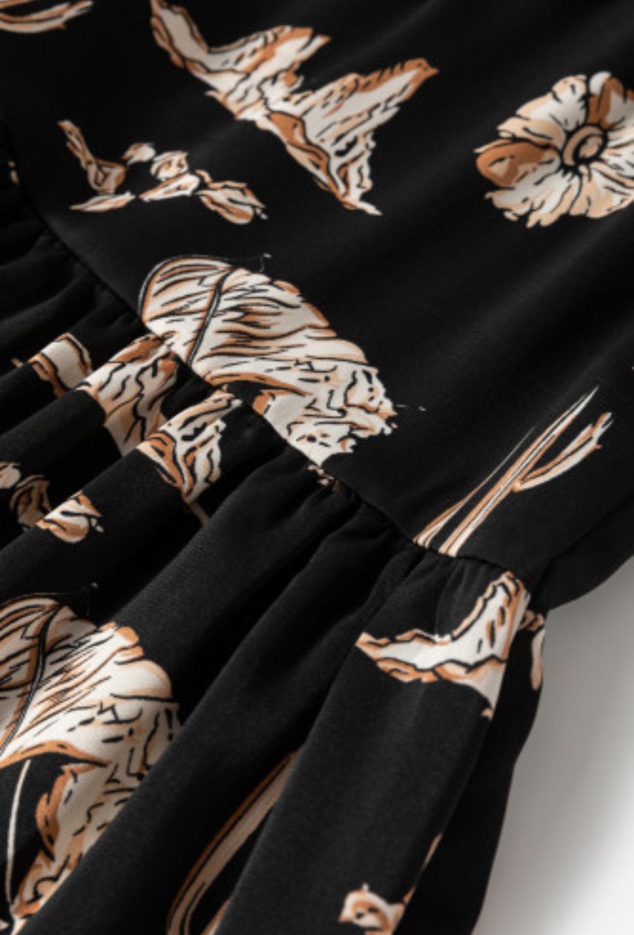 The Fall Women&#39;s Western BOHO maxi skirt features a charming western print with horses, cacti, flowers, and cowboy hats. It has a high-waisted design and a flowing silhouette in a fall color combo of black, brown, tan, and cream.