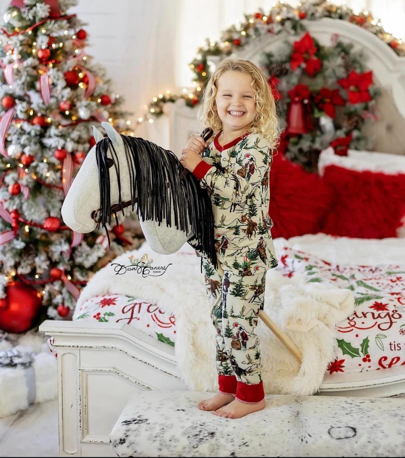 One cute cowgirl modeling her Razels Christmas pajamas in a beautiful Christmas scene.