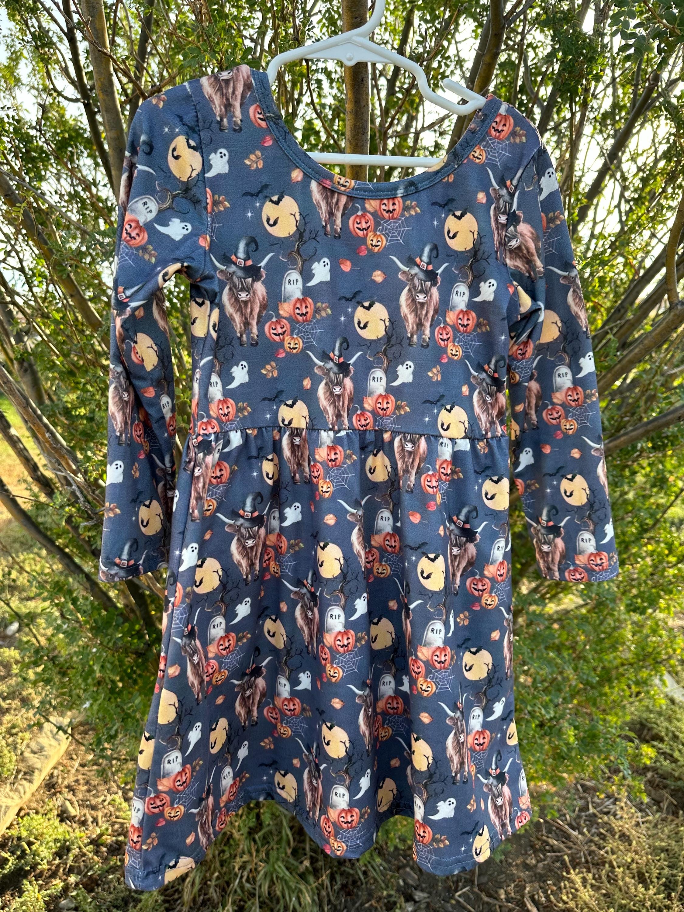 Highland Cow HALLOWEEN Dress: Western long-sleeve dress for girls featuring Highland cows in witches hats, bats, RIP graves stones, pumpkins, the full moon, spiderwebs, and more. Perfect all Fall.