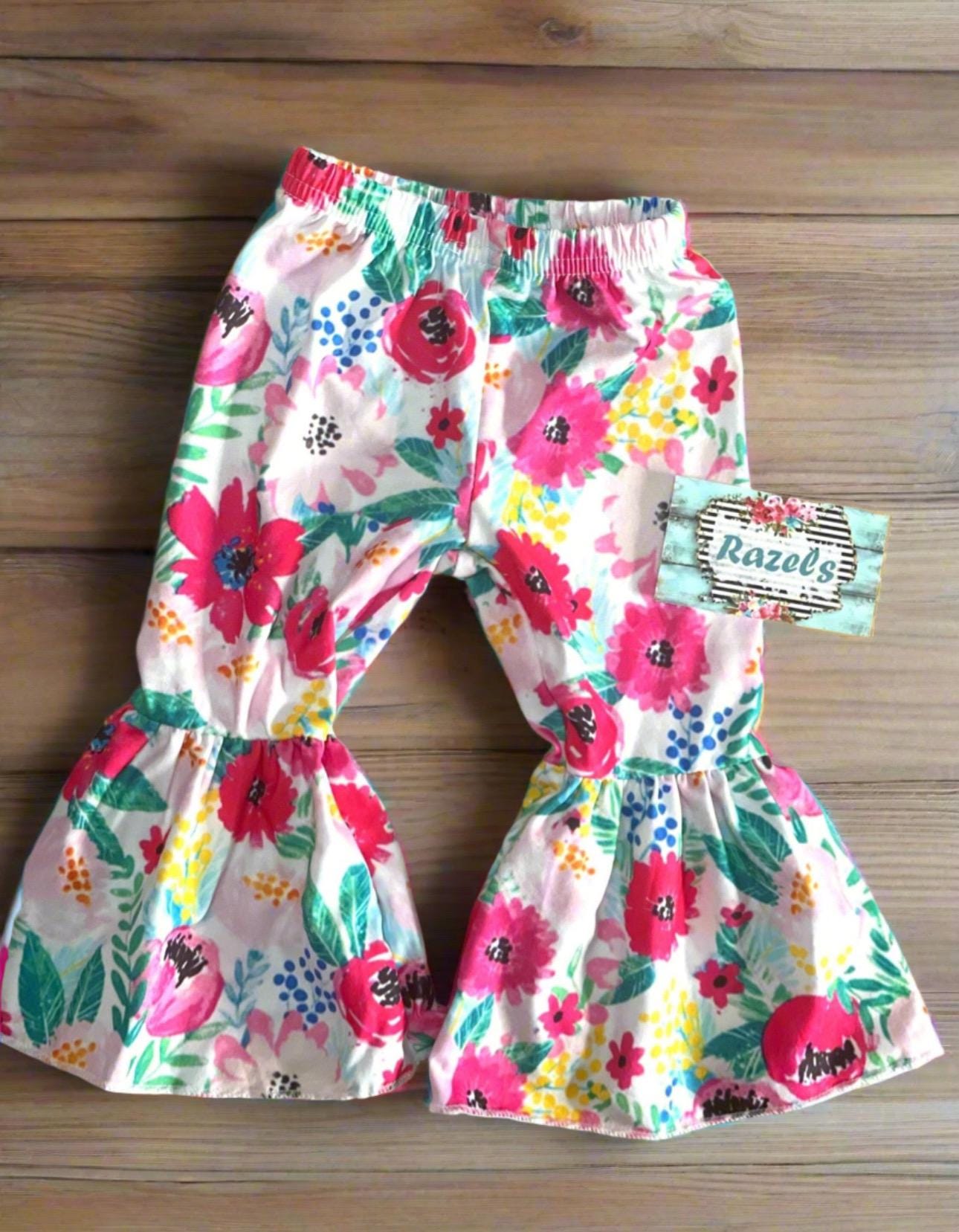 Daddy’s Little Cowgirl Bell Bottom Outfit perfect for Father&#39;s day and all Spring long! This Girls Western T-Shirt & Flower Bell Bottom Pants Set features a red &#39;Daddy&#39;s Little Cowgirl&#39; graphic T-shirt paired with vibrant flower pants bell-bottom style! Ships FREE with $35+ purchase