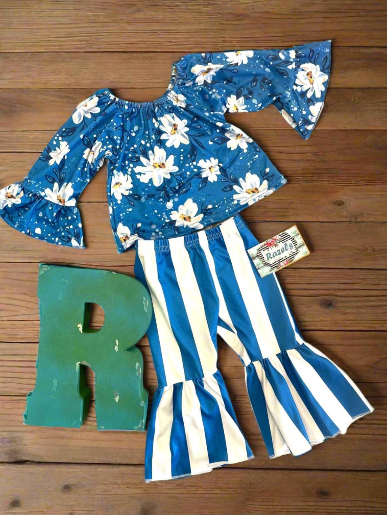 Daisy Blouse & Blue & White Striped Bell Bottom Pants Outfit is a perfect pick for SPRING ✔ Eye-catching Design: Blouse features a white daisy print on a blue blouse. The coordinating blue-and-white striped bell-bottom pants add flair to the outfit.