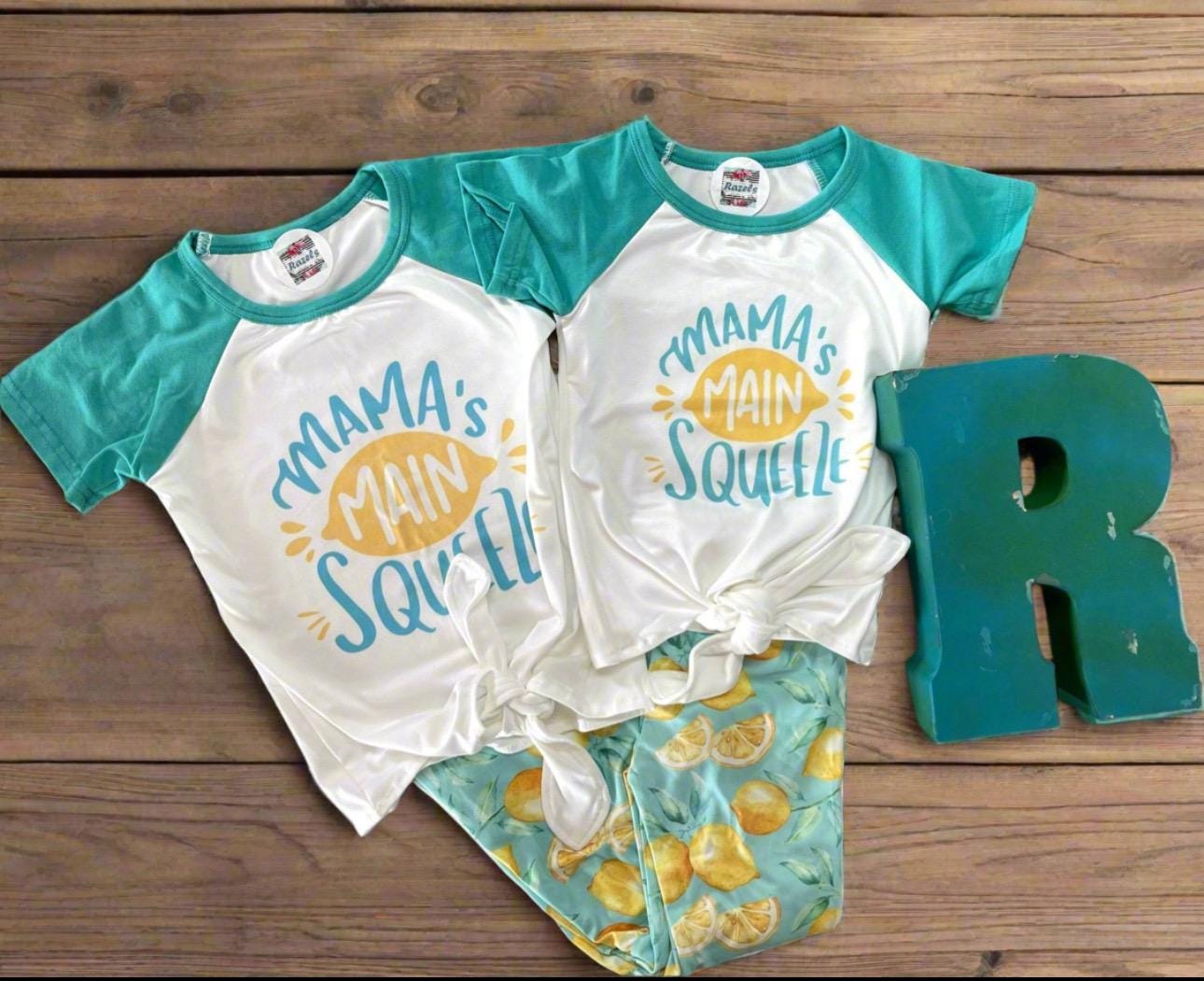 🍋 Mama&#39;s Main Squeeze Bell Bottom Outfit - a cheerful lemon-themed outfit! This adorable set features a playful &quot;Mama&#39;s Main Squeeze&quot; t-shirt and bell bottoms with an all over lemon print, adding a burst of sunshine to any day.